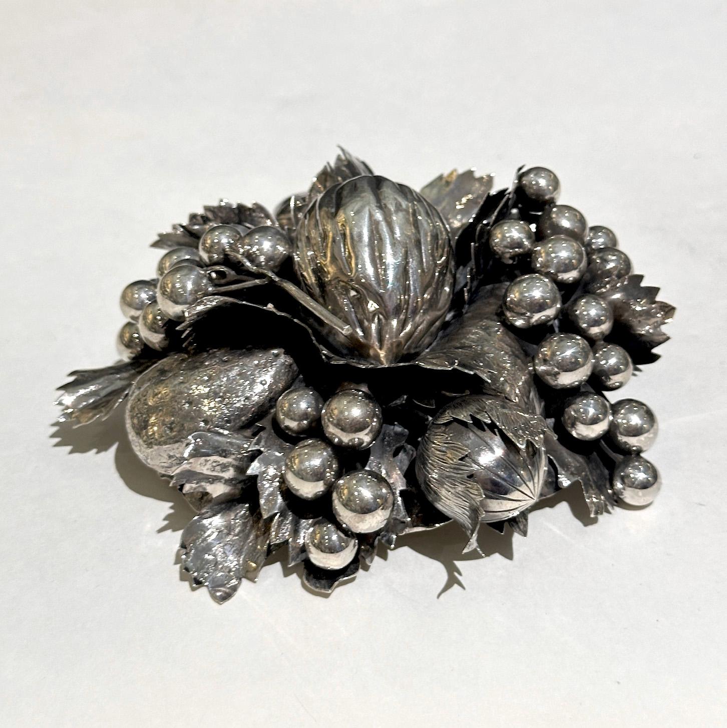En excelente estado, lista para adornar tu mesa. Esta refinada pieza de plata de ley es una creación de la renombrada casa Buccellati, célebre por su intrincado trabajo con metales preciosos. Presenta una composición meticulosamente elaborada de
