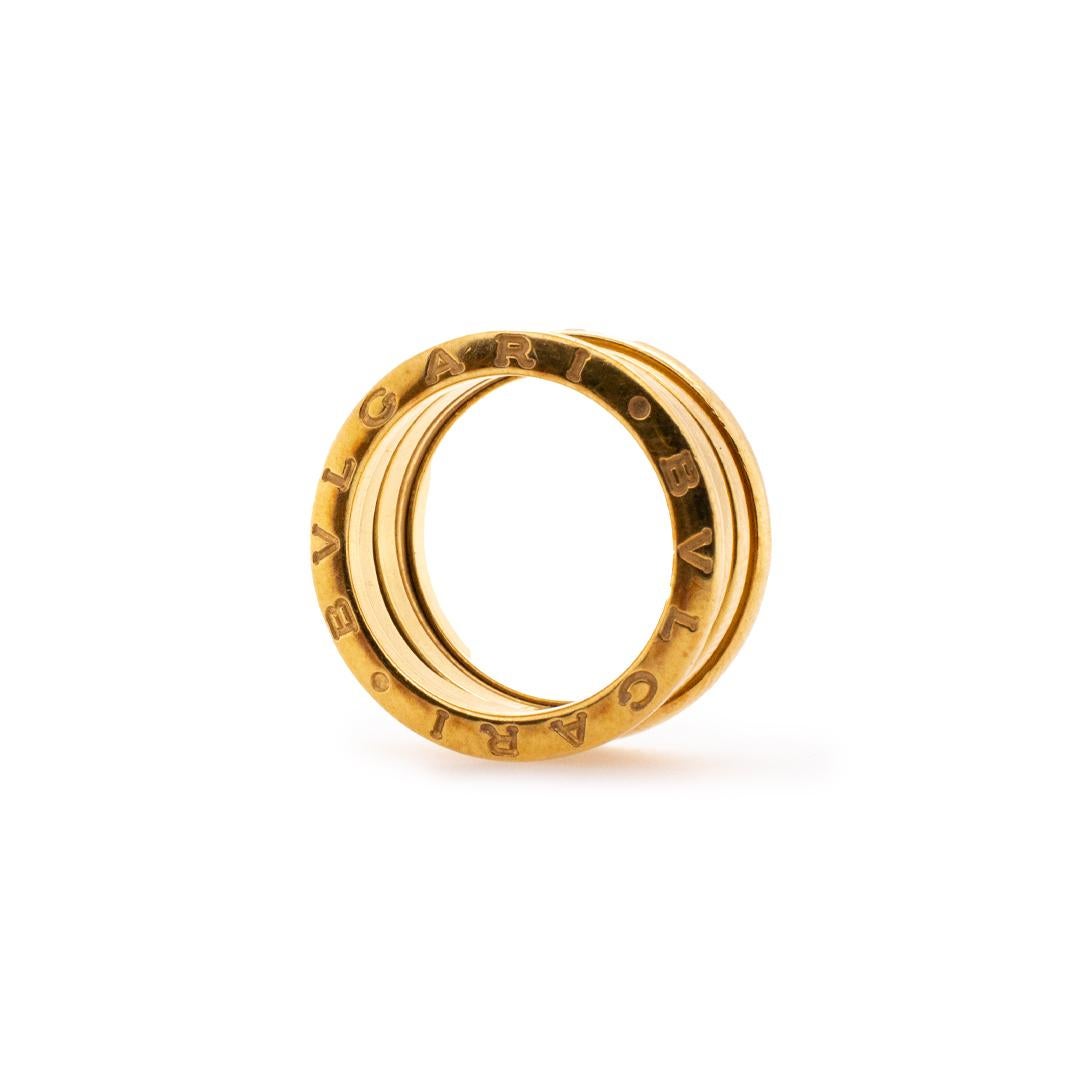One lady's designer made polished 18K yellow gold interlocking, soft-square, wedding, anniversary, solitaire, trinity band with a knife-edge shank. The band is a size 6 and measures approximately 9.50mm in diameter and weighs a total of 10.33 grams.