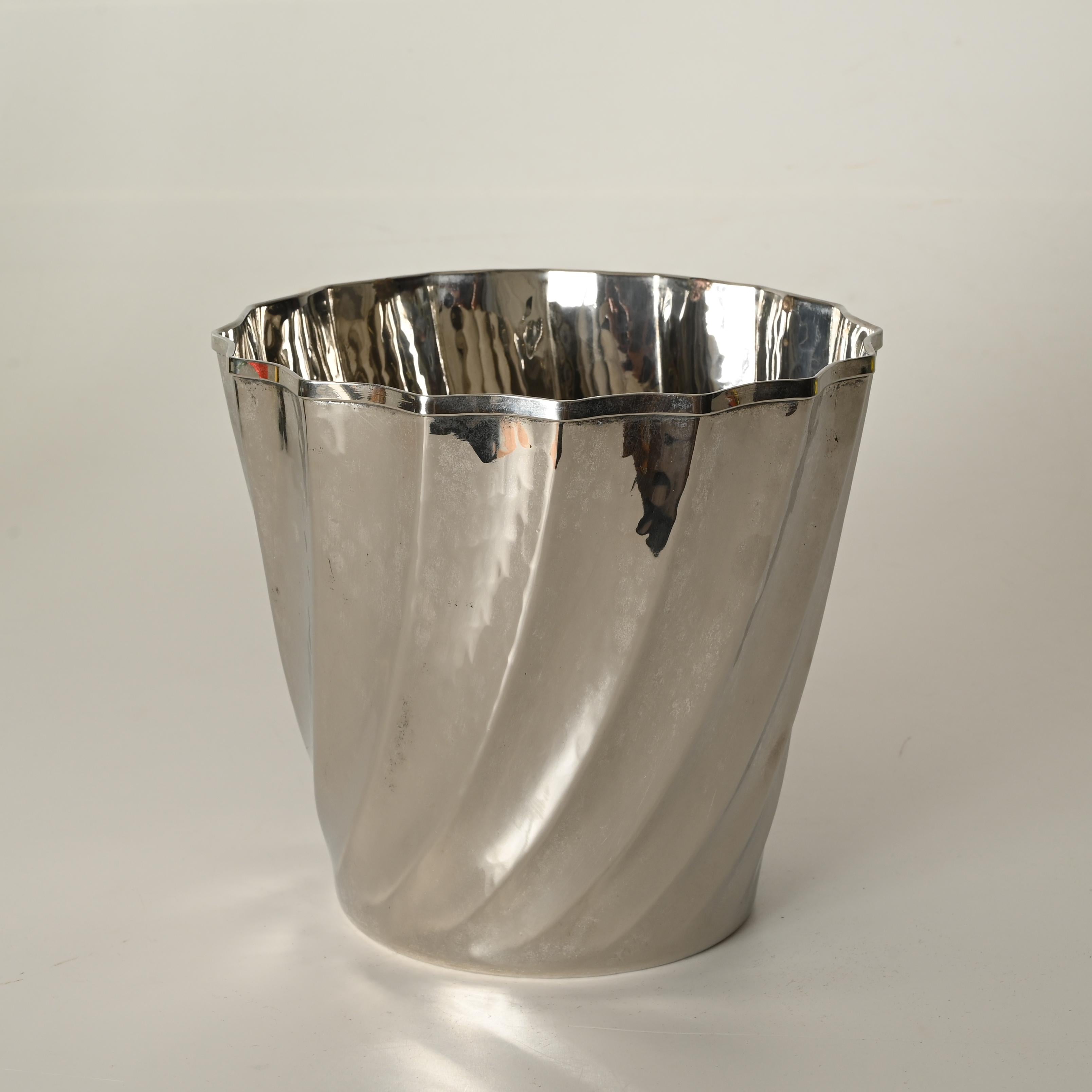 Gorgeous Mid-Century ice bucket in hammered silverplate. This incredibly stylish piece was hand-made by Calegaro in Italy during the 1970s and is signed on the bottom and on the side.

This elegant ice bucket features a curved, multifaceted hammered