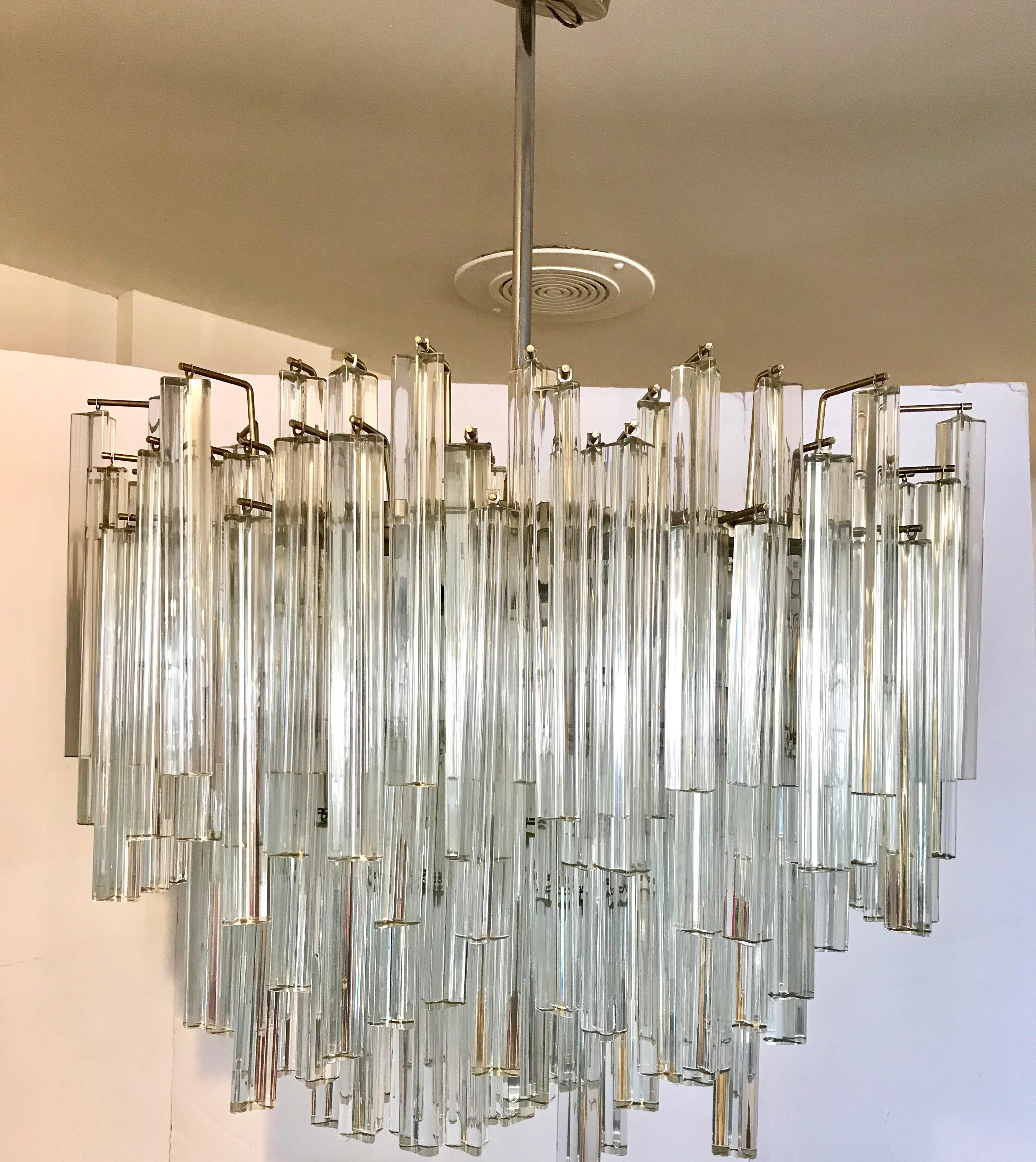 Stunning signed Camer glass midcentury monumental waterfall chandelier. The waterfall design is
realized by Camer's use of two different sized Murano glass prisms. The light that reflects off this work of art is truly unique.