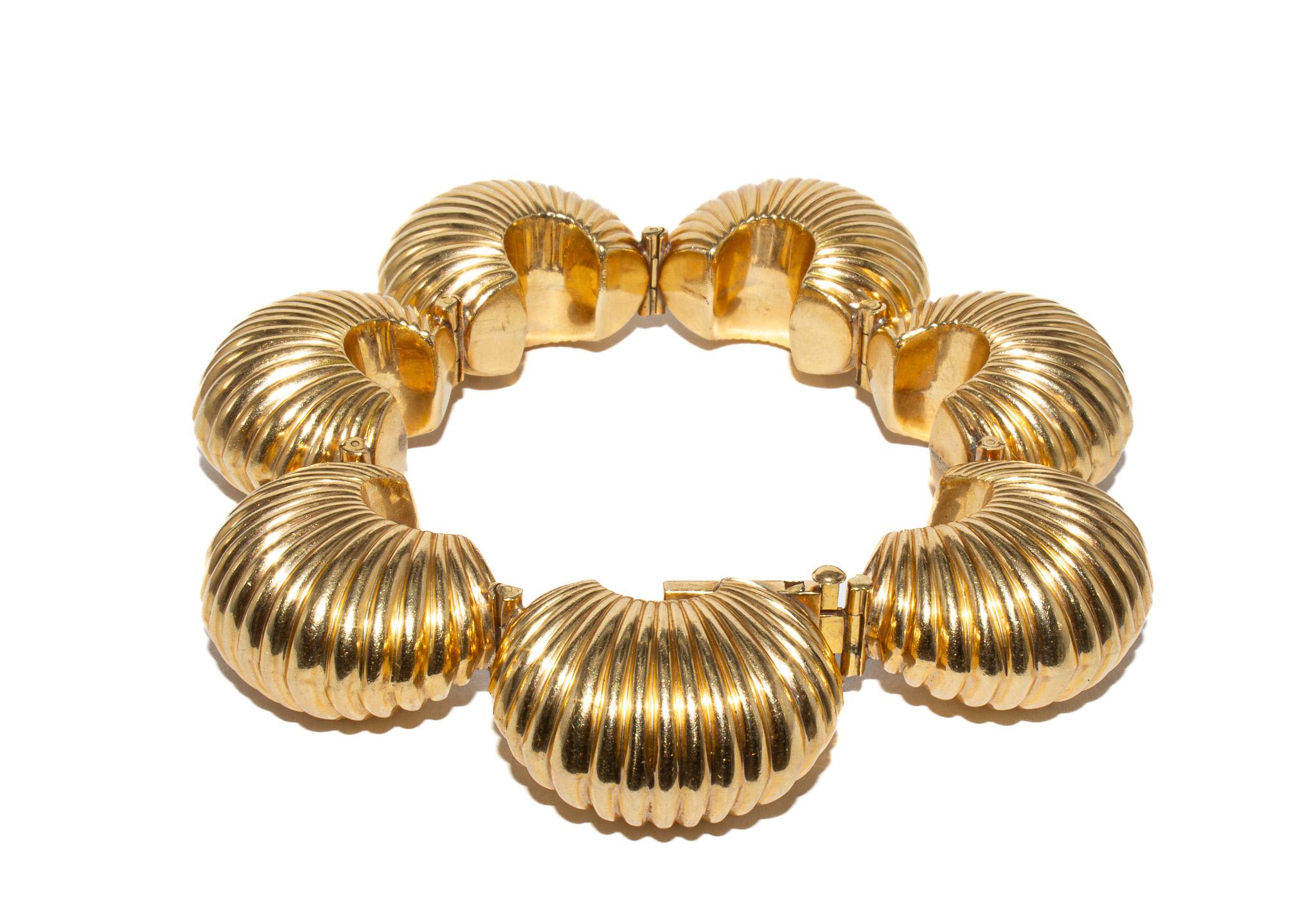 This bold and beautiful vintage set from Cartier showcases the iconic bombe fluted dome design that defined the brand’s high-style look of the 1980s. Crafted in 14K yellow gold, the set includes a pair of clip-on earrings, a coordinating bracelet,