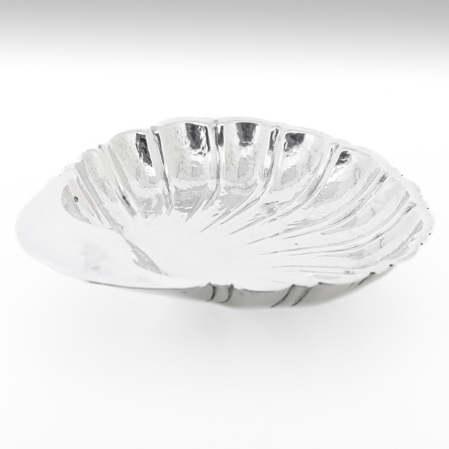 A fine silver shell dish or vide poche.

In sterling silver.

By Cartier.

Model no. 528

With fine hand-hammered work throughout.

In the form of scalloped seashell shape Horringer-type low tab handled bowl.

Simply a wonderful Cartier