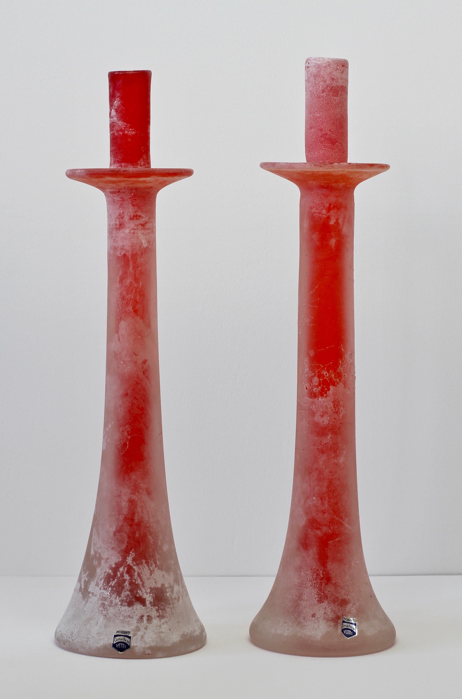 Beautiful, tall and rare signed pair of Scavo glass candlestick holders by Cenedese Vetri Murano glass in collector's condition. Made of red Murano art glass featuring the 'scavo' technique, giving the glass the resemblance of historic roman glass