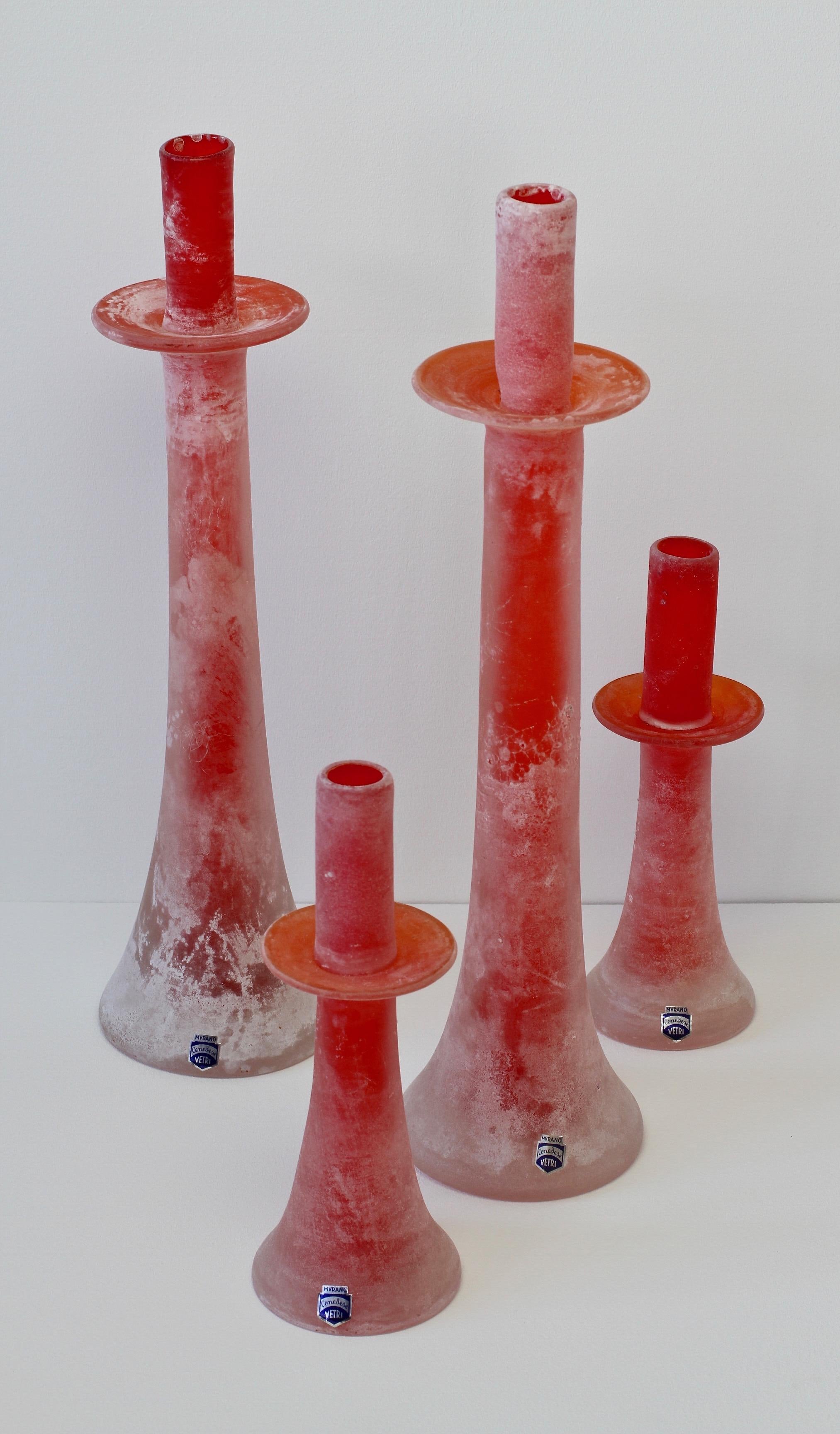 Signed vintage Mid-Century ensemble of red Scavo glass candlestick holders by Cenedese Vetri Murano glass in collector's condition. Made of red Murano art glass featuring the 'scavo' technique, giving the glass the resemblance of historic roman