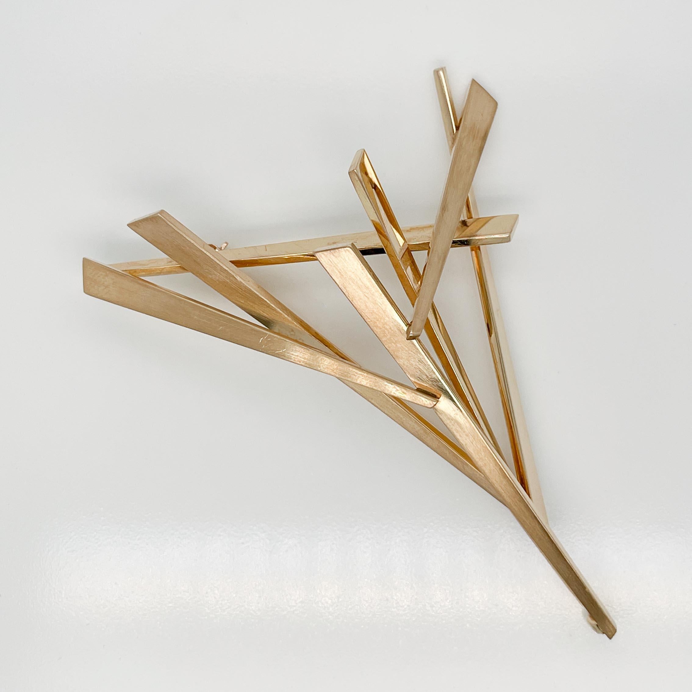 A fine Modernist 14k gold brooch.

By Charlie March.

In 14k gold

With seven tapered solid 14k gold elements overlapping to form a triangular pattern. 

The design of this brooch looks different from every angle and perspective. 

Simply a