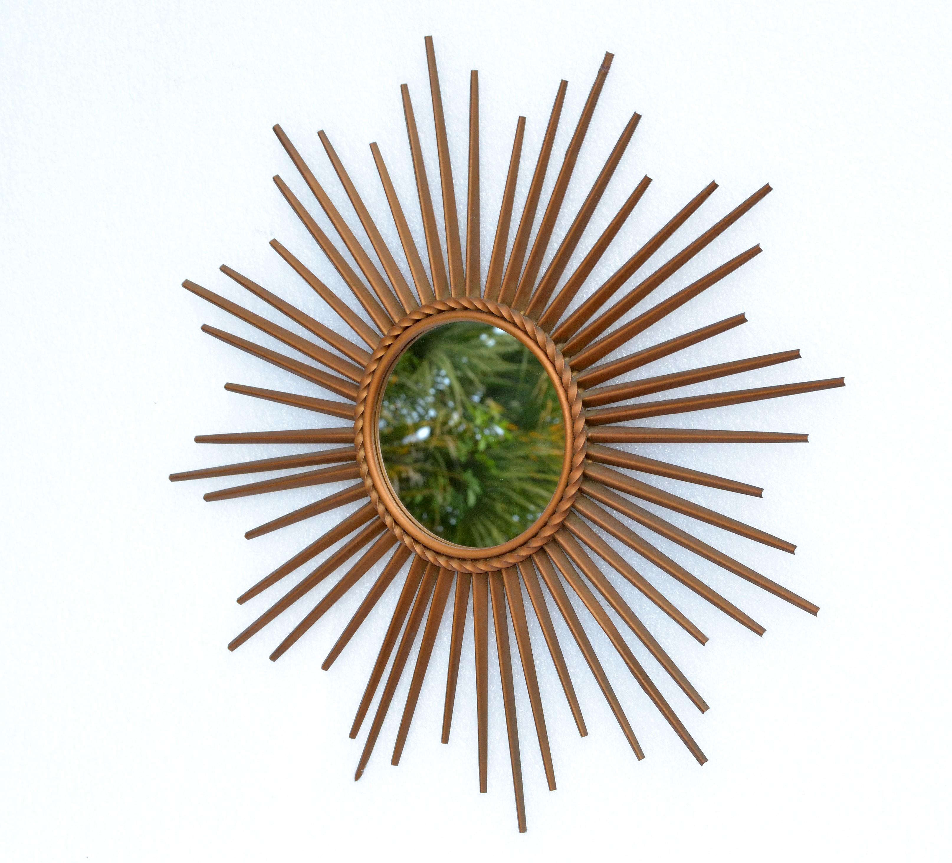 French Mid-Century Modern sunburst mirror by Chaty Vallauris and made in the 1970s.
Stunning handcrafted iron overlaid in brass finish with a 5.5 inches flat mirror in the center.
Made in Vallauris, France.
Mirror is marked on the reverse.
Photo