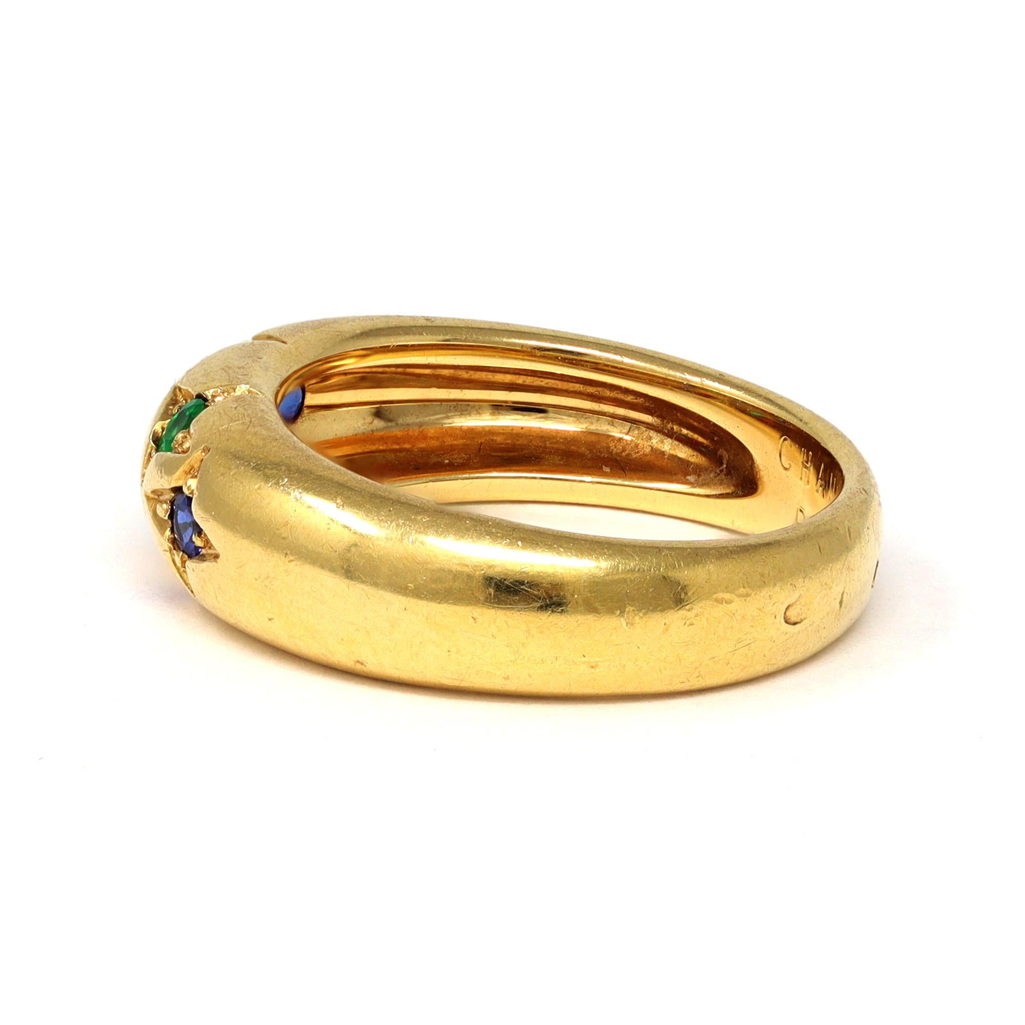 The small band ring is signed by the French house of Jewelry Chaumet Paris. It features multicolor round stones such as rubies, emeralds and sapphires of excellent quality and saturation. The ring is made in 18 karat yellow gold and has a gross