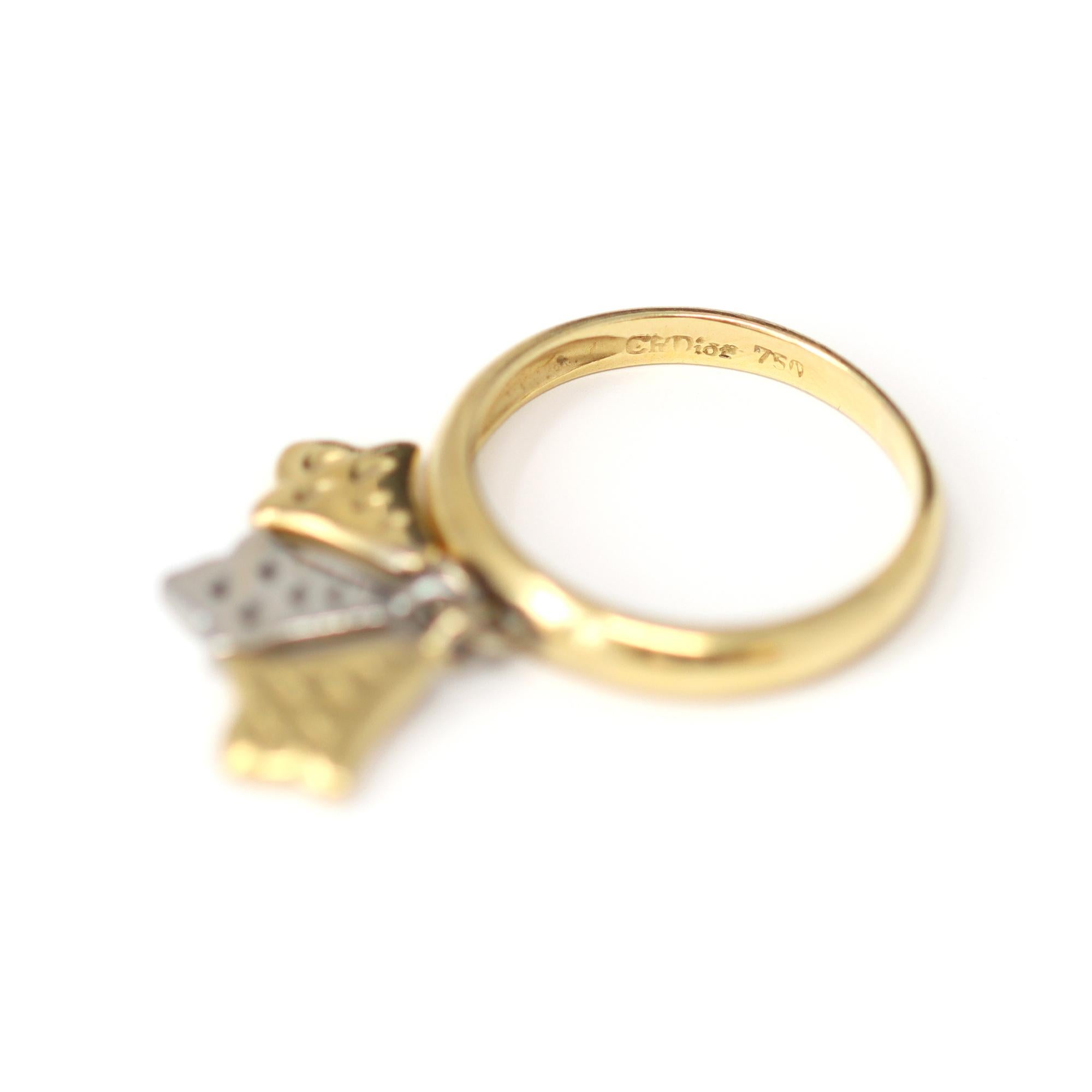 Un giocoso anello con ciondolo dell'iconica casa di Christian Dior. L'anello a tre bracci, unico nel suo genere, è realizzato in oro giallo 18 carati e uno dei charme è in platino. Veste una taglia 6½ e ha un peso lordo di 5 grammi. L'anello è