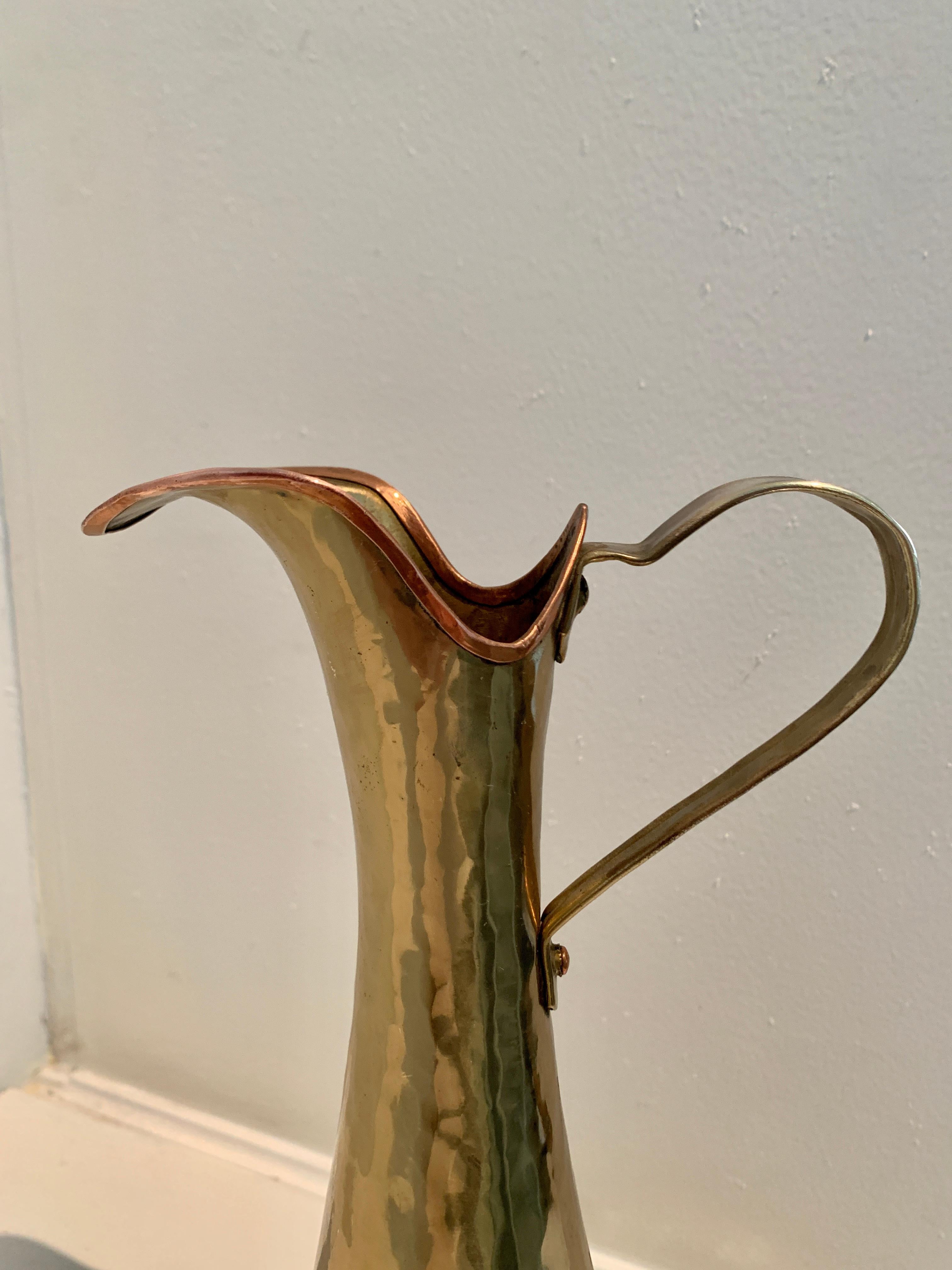 A wonderful pitcher of hammered brass with a copper lip and fittings. The piece is a compliment to any shelf, work station or garden area. Water your plants or serve delicacies, from tea to oil! a lovely shape and sophisticated design that easily