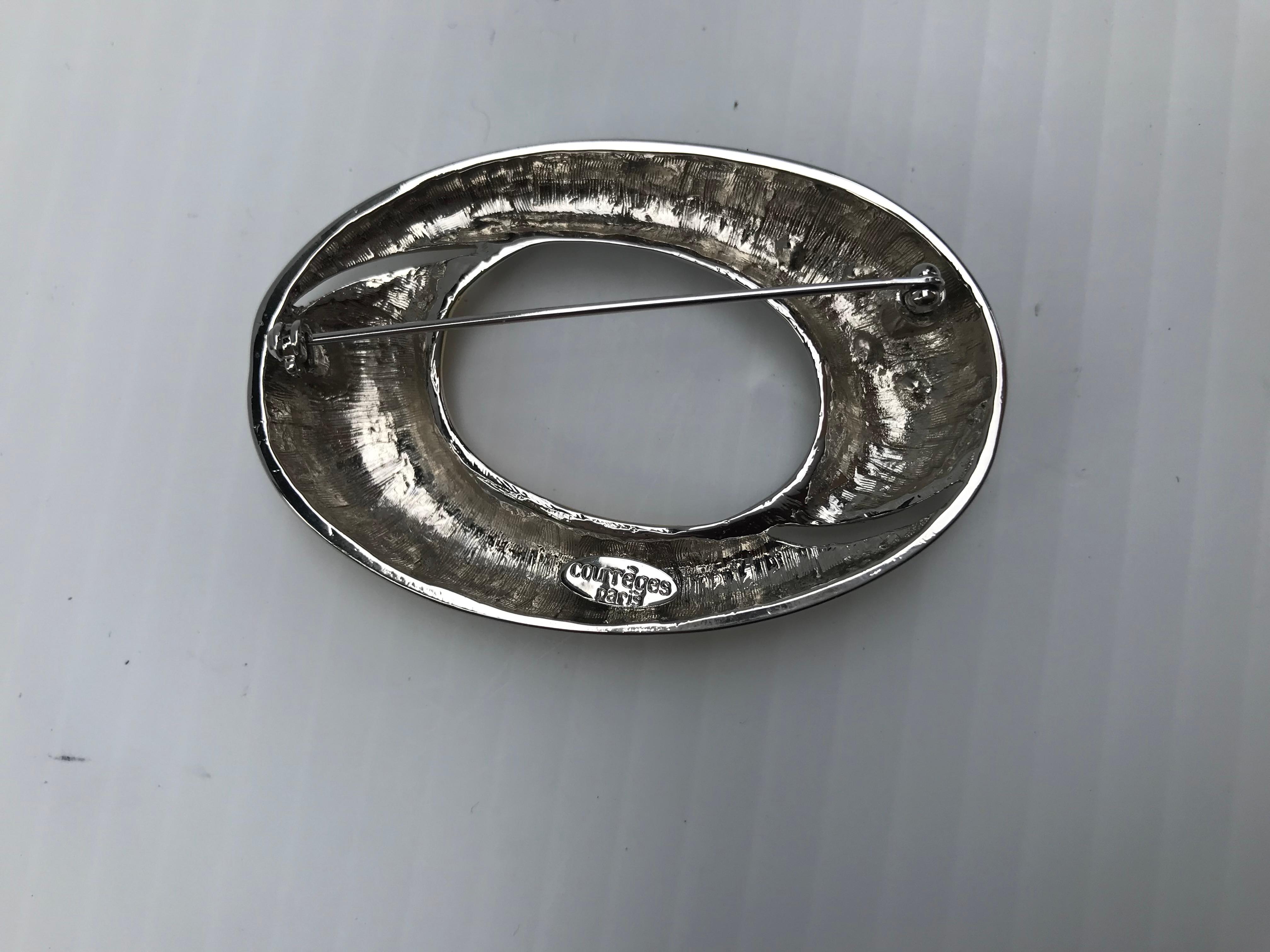 Firmata Courreges Paris, spilla in metallo dorato bianco e dorato con cristallo Swarovski, fine del XX secolo, marcata sul retro, realizzata in Francia, 