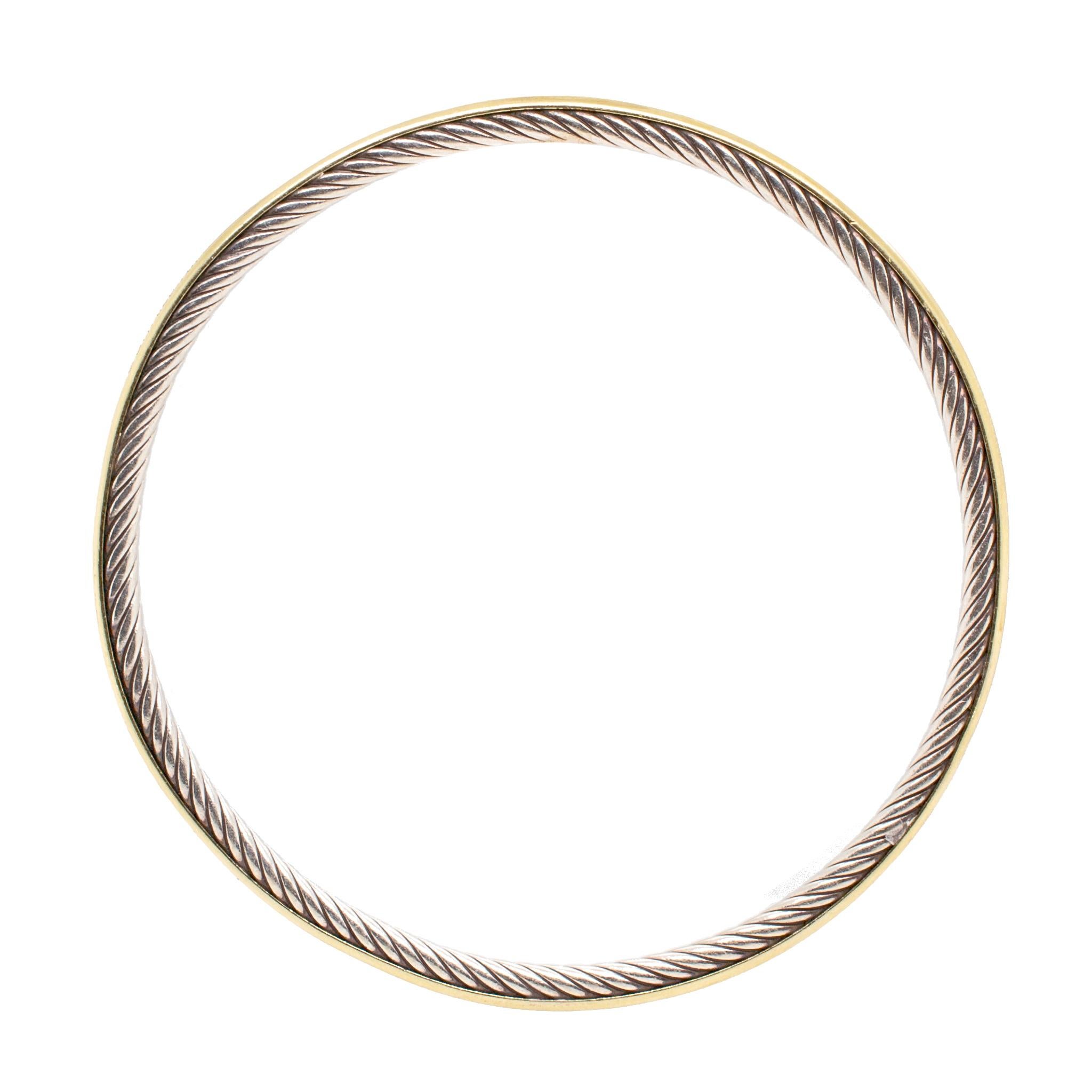 One lady's designer made textured & polished, 18K yellow gold and silver, bangle bracelet. The bracelet is 3.75mm thick and measures approximately 7.50 inches in length by 2.82mm in width and weighs a total of 13.50 grams. Engraved with 