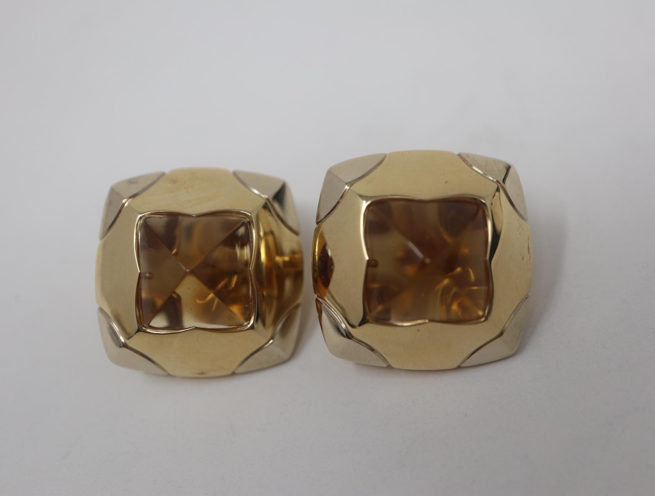 Signed designer Bulgari earrings designed in 18 karat yellow and white gold. The earrings contain four sided cabochon natural Citrine gemstones with post and omega clip backing. The earrings measure 30mm x 30mm. 