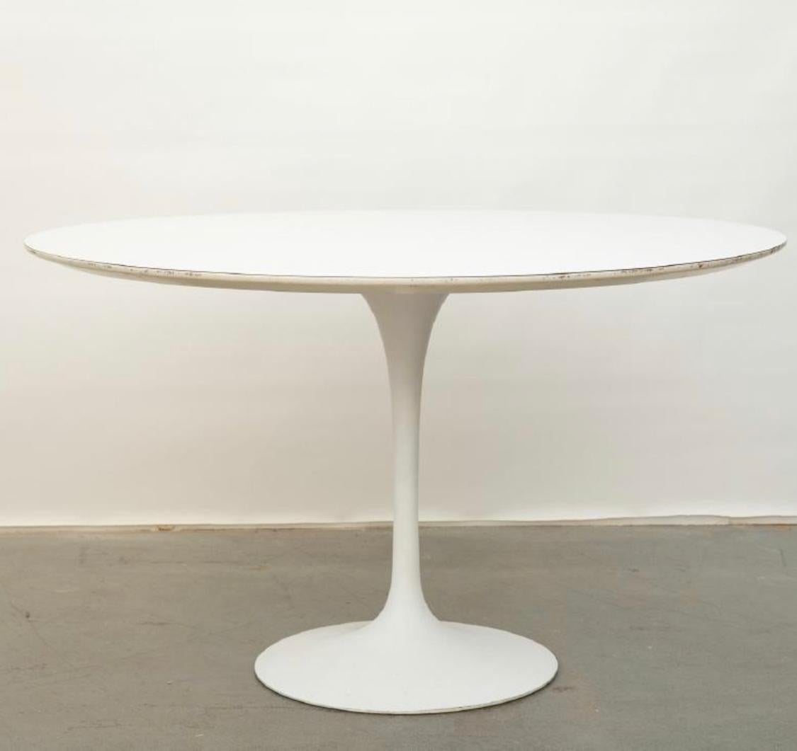 Classic and sleek Tulip dining table designed by Eero Saarinen for Knoll. Signed with original manufacturer label. Cast aluminium base supporting white laminate top. Measures: 48 inches in diameter. Easily accommodates 6 dining chairs.