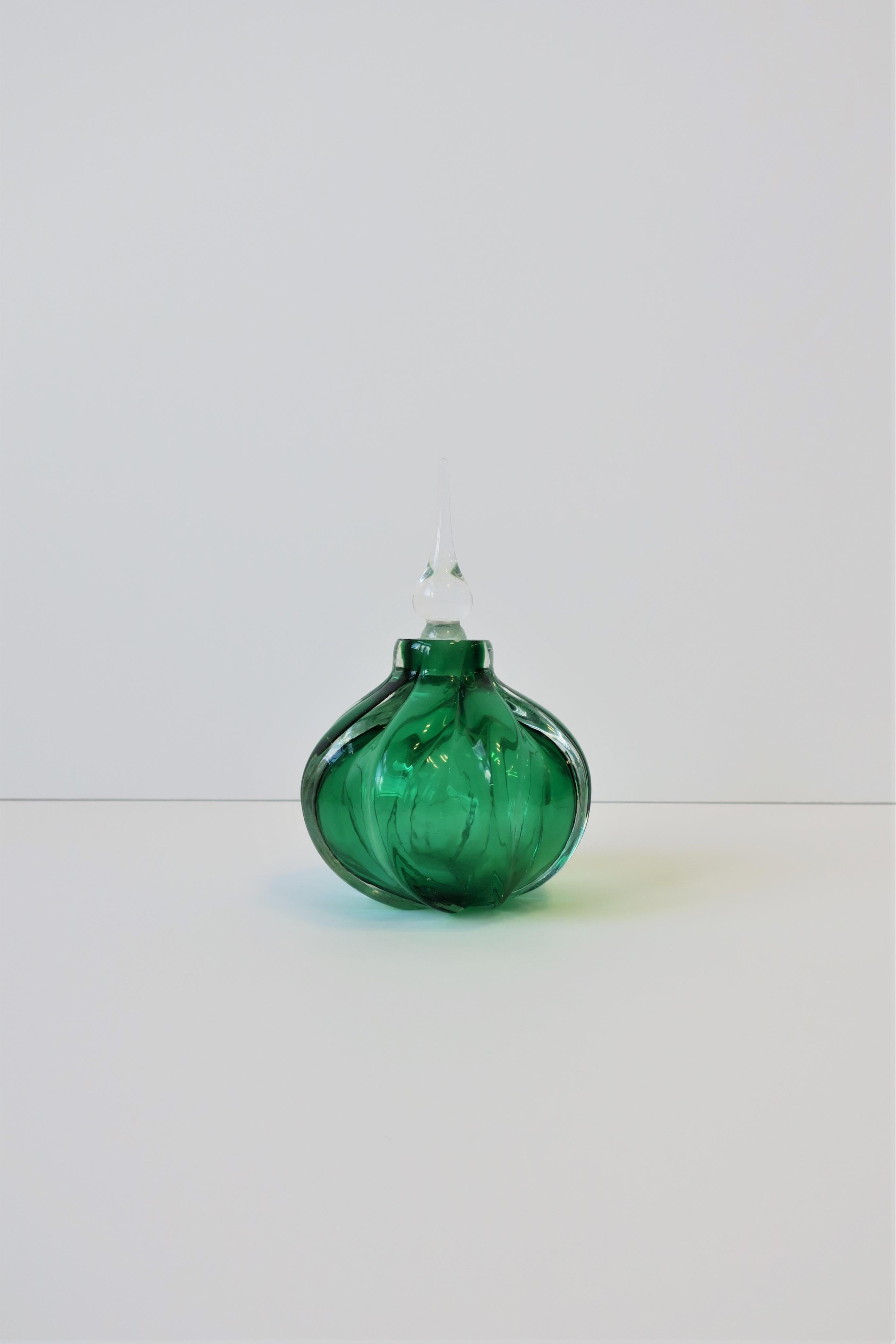 A very beautiful and substantial Emerald green art glass perfume vanity bottle signed and numbered on bottom, circa mid-20th century. Bottle is Emerald green and clear art glass, round with fluted design, and clear art glass bottle stopper. Signed