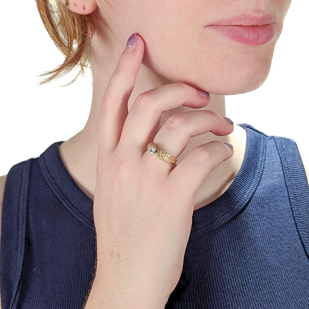 Un raffinato anello di fidanzamento modernista in studio.

Con montatura in oro giallo 14k.

Incastonato con un diamante bianco rotondo taglio brillante. 

Il gambo asimmetrico ha una decorazione incisa ed è contrassegnato da un marchio di fabbrica