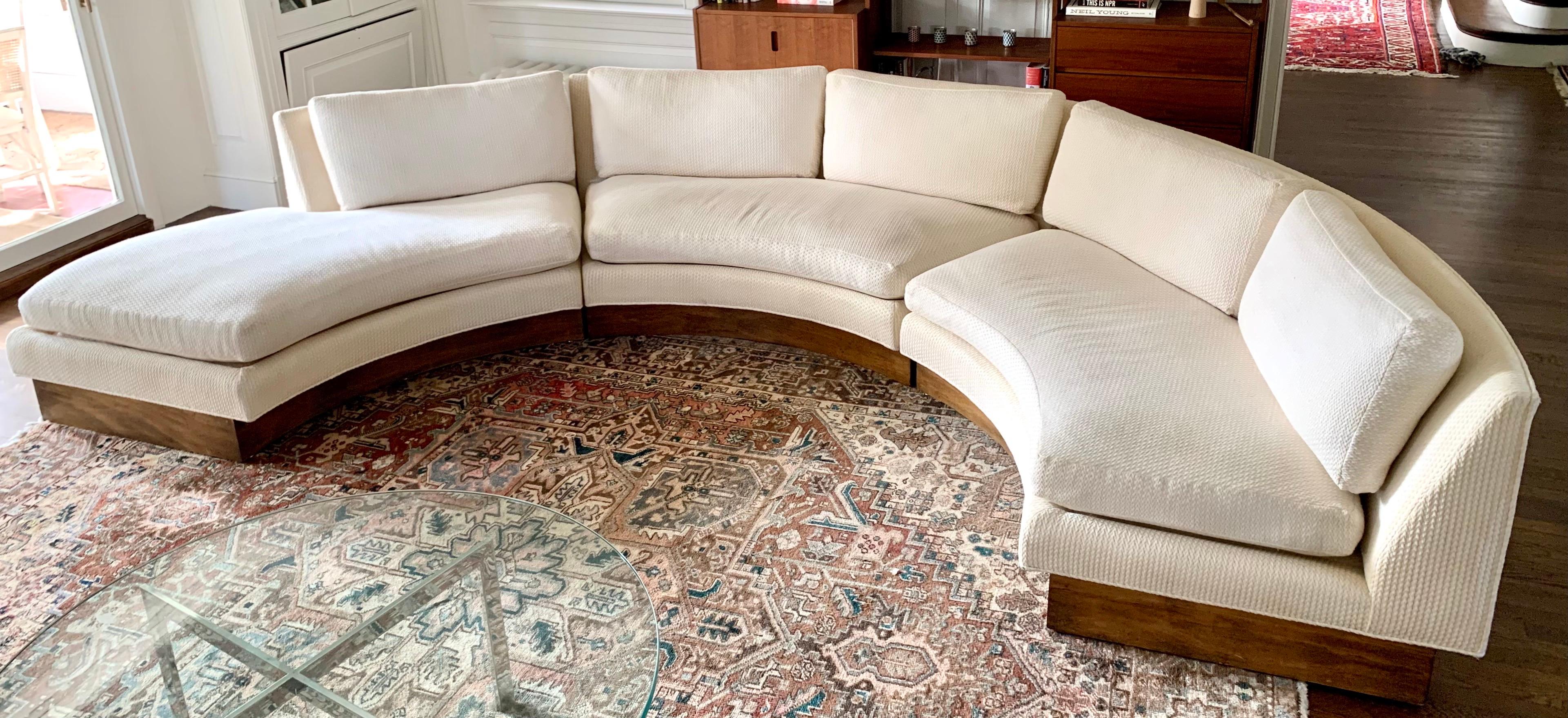 Stunning, large scale curved sectional sofa by esteemed Erwin Lambeth. Signatures on interior of pillows.
It is shaped as a semi-circle and sits on a walnut plinth. There is some minor chipping on the back of the walnut plinth as shown in pics. The