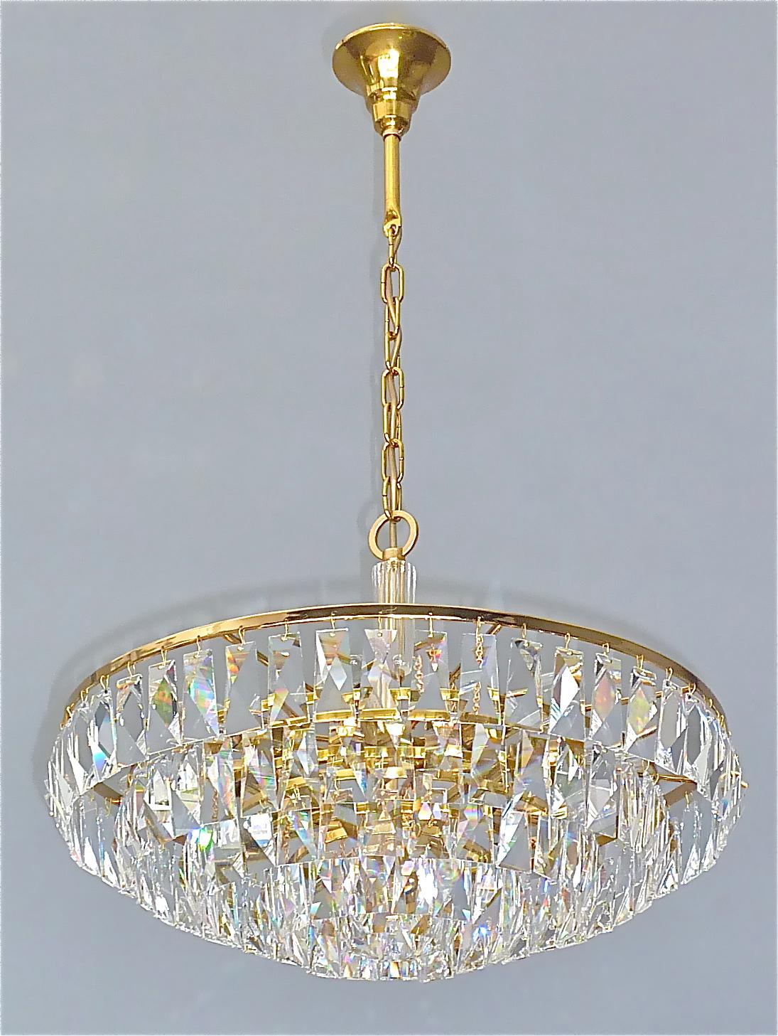 Fine large gilt brass and crystal glass chandelier made by Palwa, Germany, circa 1960. Signed with the company label Palwa inside the canopy the chain-hanging length-adjustable chandelier has a crystal glass stem in the center and five gilt brass