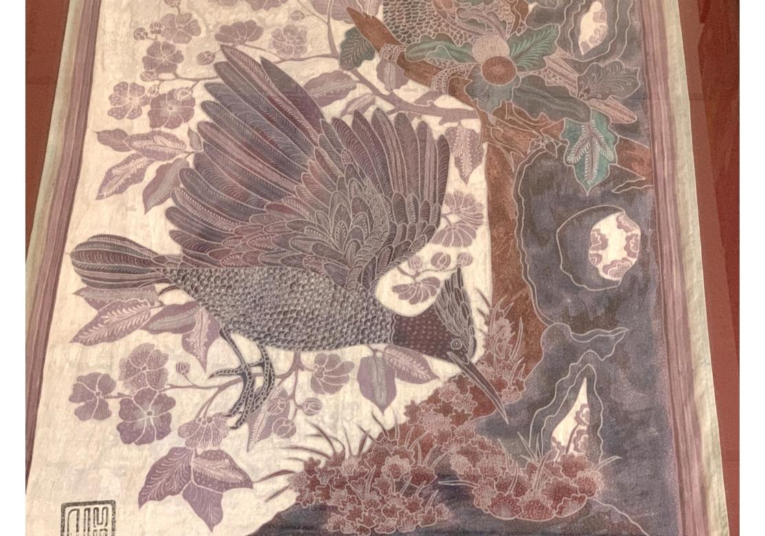 A very well made and decorative Asian weaving depicting two Flycatcher Birds in a Forest setting. One alert bird holds a fly in its beak as the other searches a floral patch. With subtle colors of Gray, Plum and Burgundy, the Forest is filled with