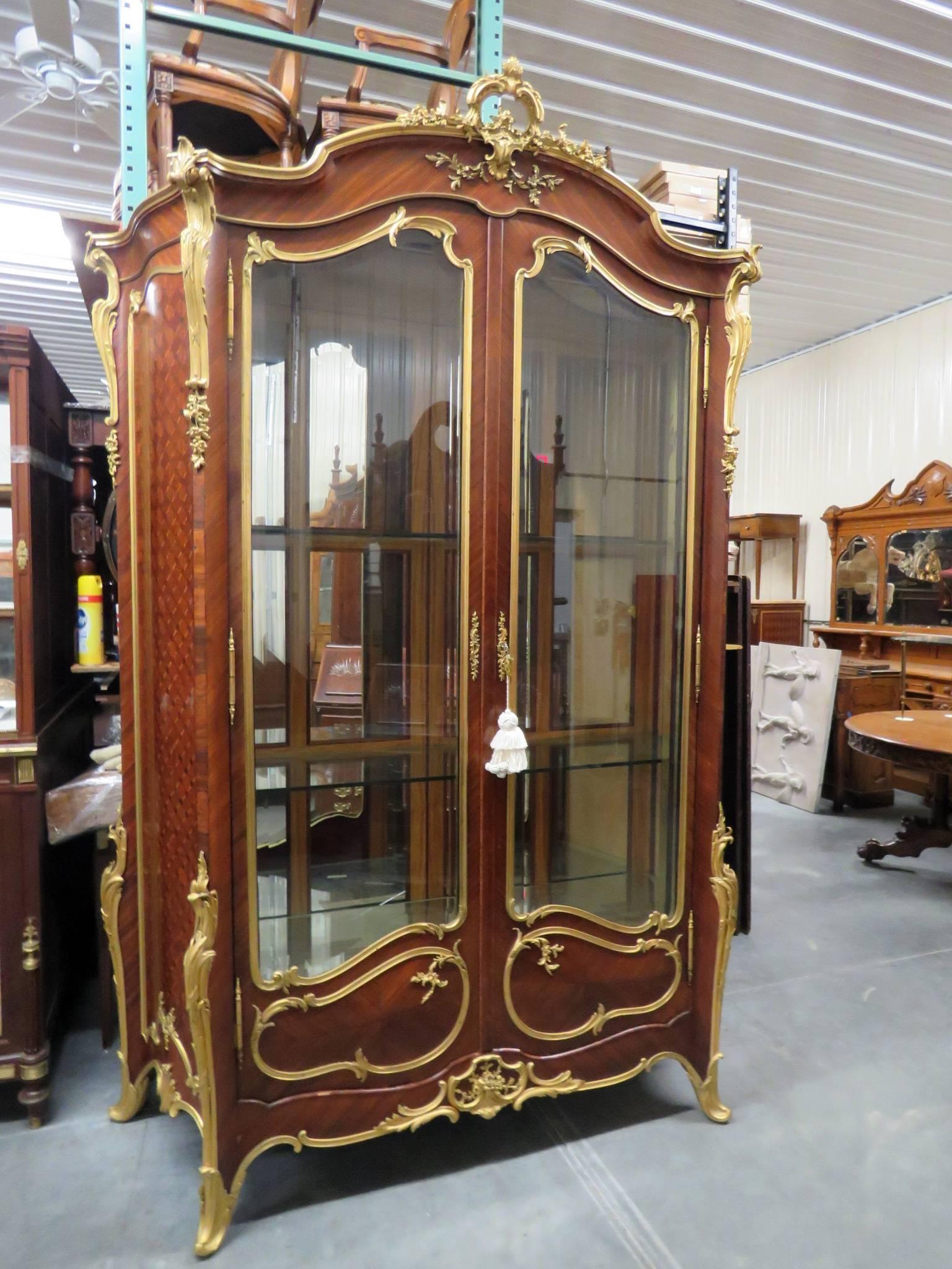 This is an outstanding and truly majestic one of a kind vitrine by the famous ebeniste Francois Linke. The piece has two beveled glass doors and incredible king wood marquetry and serpentine sides. The bronze is all completely finished in gold dore'