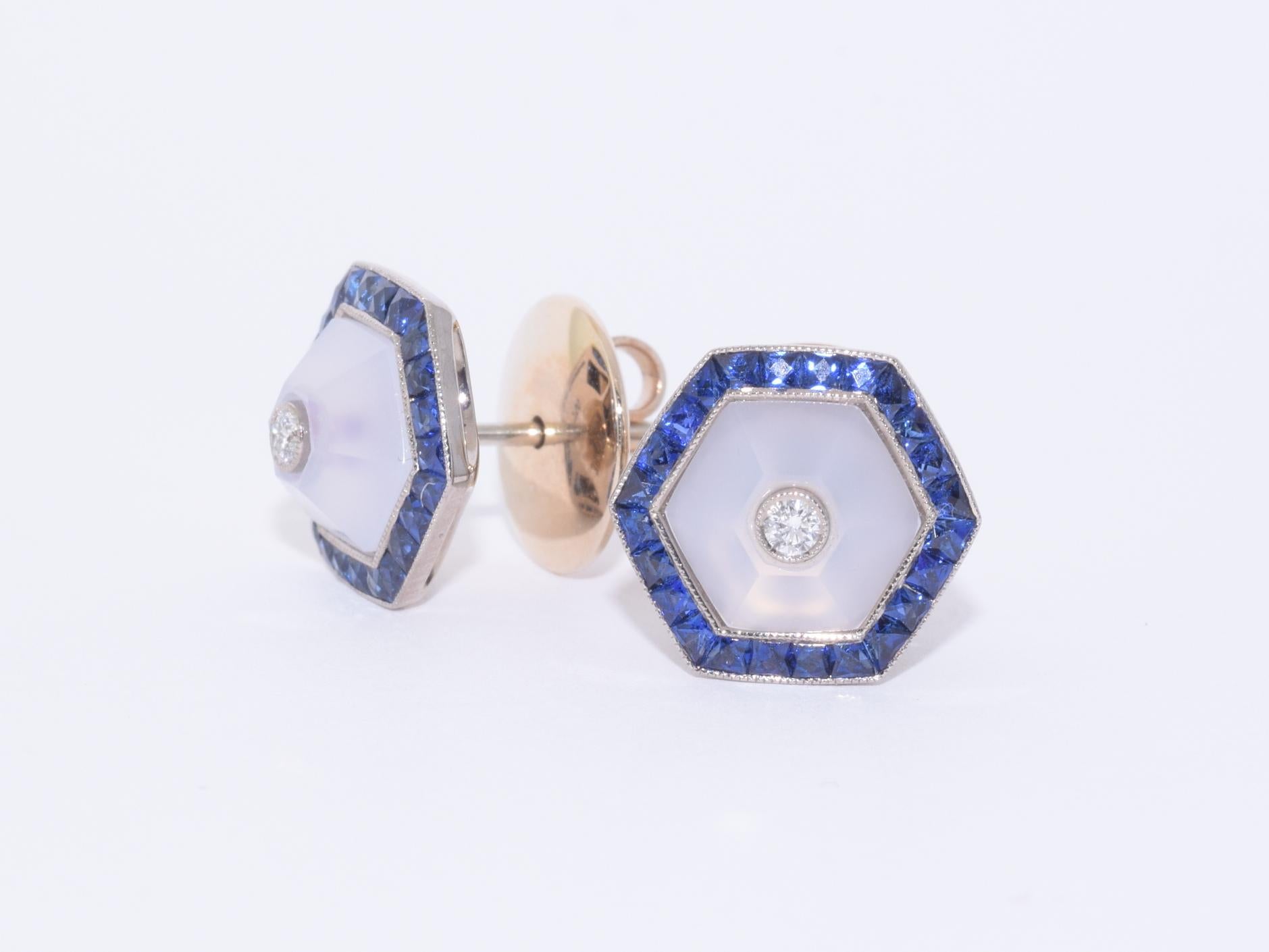 Hexagonal cut blue chalcedony is inlaid with round diamonds totaling approximately 0.05 carat and is set in a calibre sapphire surround totaling approximately 0.40 carat in an 18 karat white gold mounting. 11.9mm at widest point.

Fred Leighton is