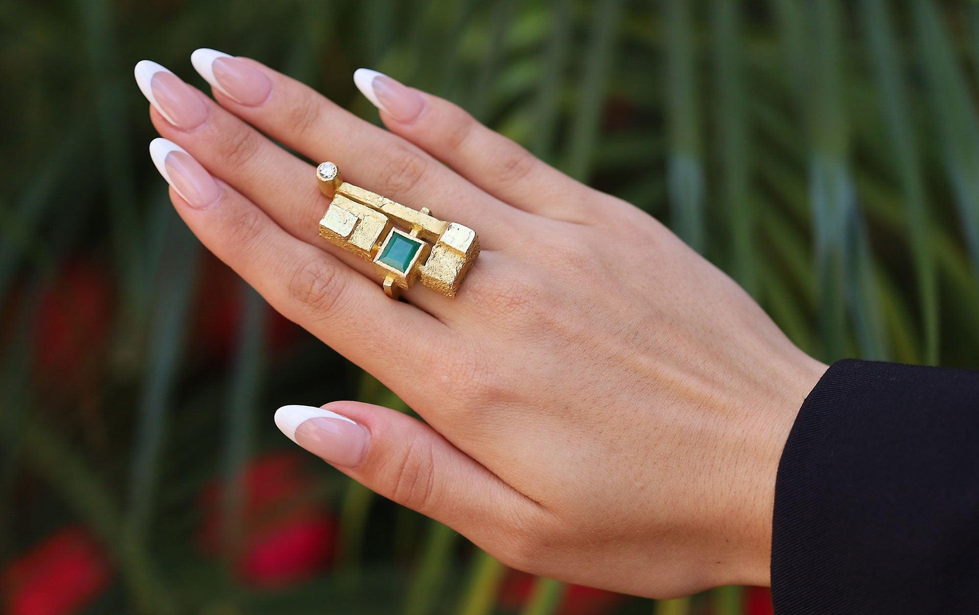 A fabulous Fred Leighton brutalist cocktail ring. This signed, vintage heirloom featuring a 4 carat emerald cut emerald and a round diamond set in a funky, geometric configuration. Brutalist designs are sought after by collectors and the Leighton