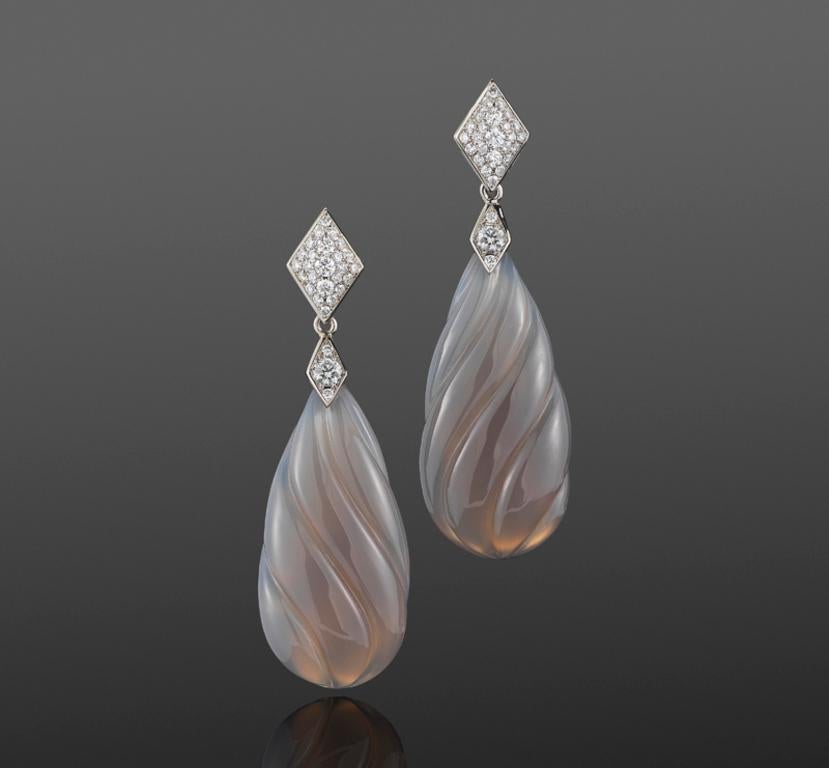 Carved grey chalcedony drops are suspended from lozenge motifs set with a total of approximately 0.67 carats of round diamonds mounted in 18 karat white gold.  Signed Fred Leighton.
Length: 2 inches. Width: 5/8 inch.

Fred Leighton is renowned for