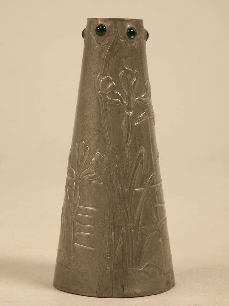 French Art Nouveau metal vase. Signed Lola 1911. The top is embellished with green glass cabochons and the body is decorated with dimensional flowers and birds.