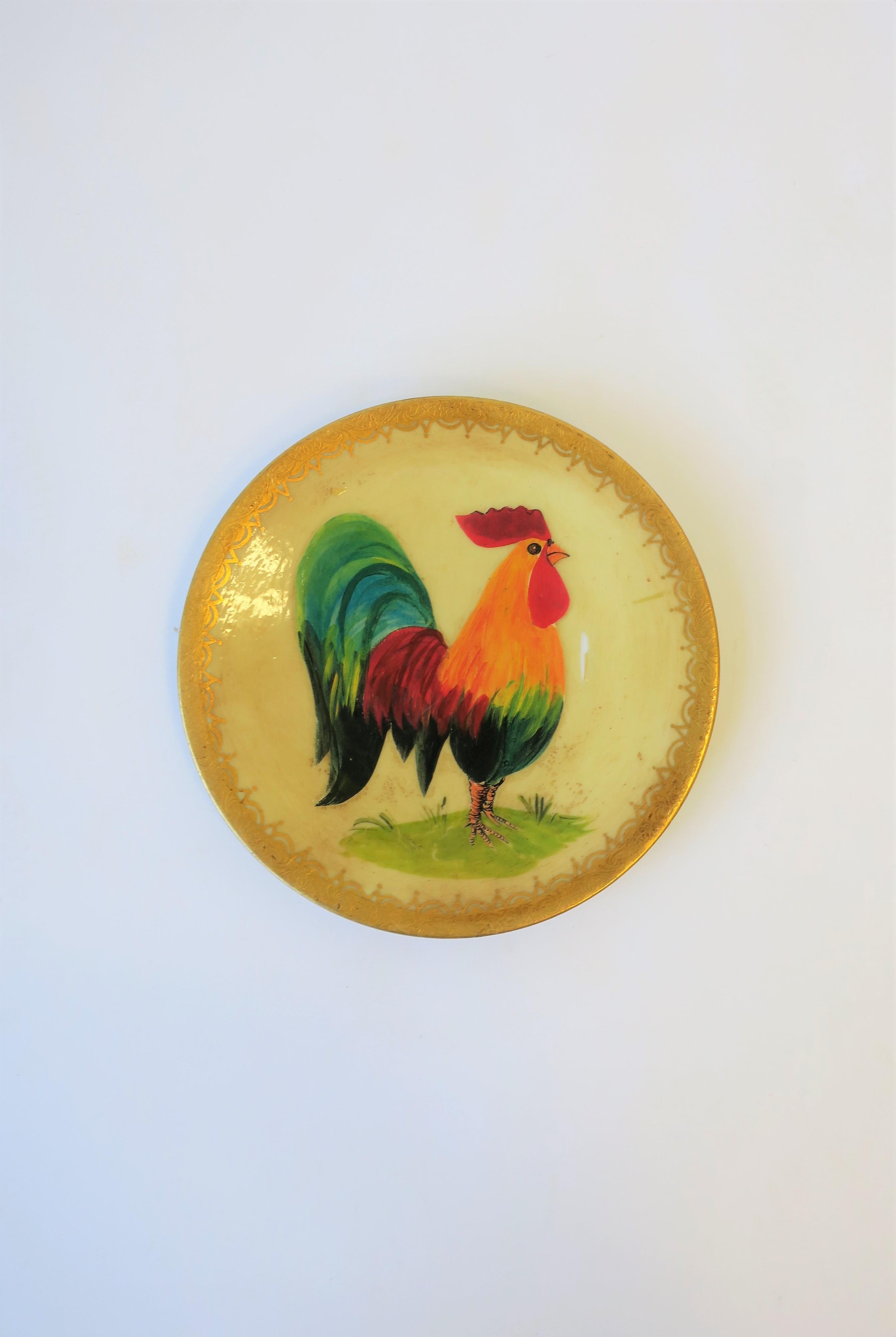 A beautiful French porcelain hand painted wall art plate with colorful Rooster bird and gold gilt edge by artist A.A. Rose, circa early 20th century, France. Plate bears maker's mark and artist signature on back: Artist 
