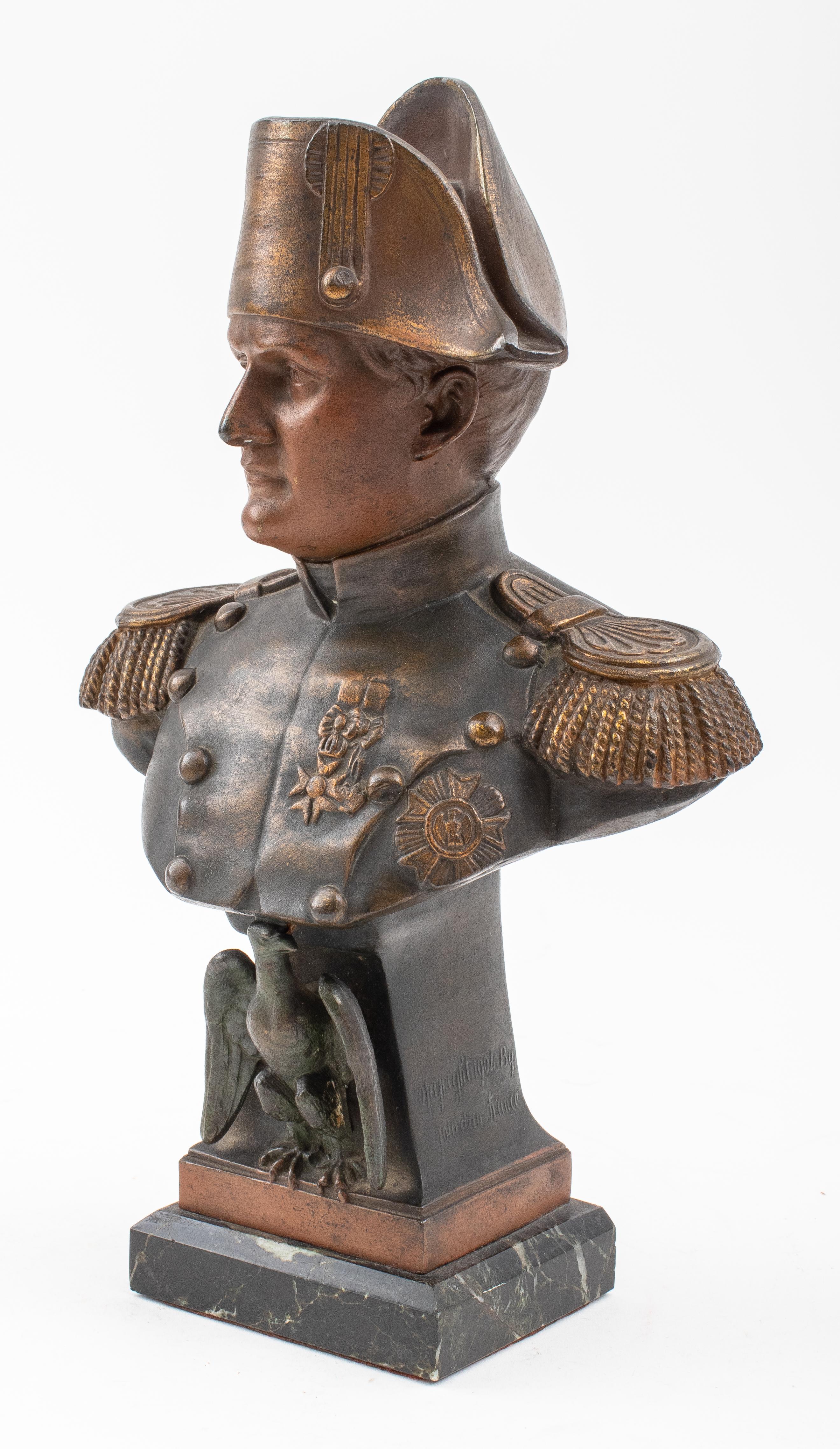 French spelter bust depicting Napoleon donning a bicorne cocked hat, upon a columnar stand with an eagle mounted on a black marble base, stand signed 