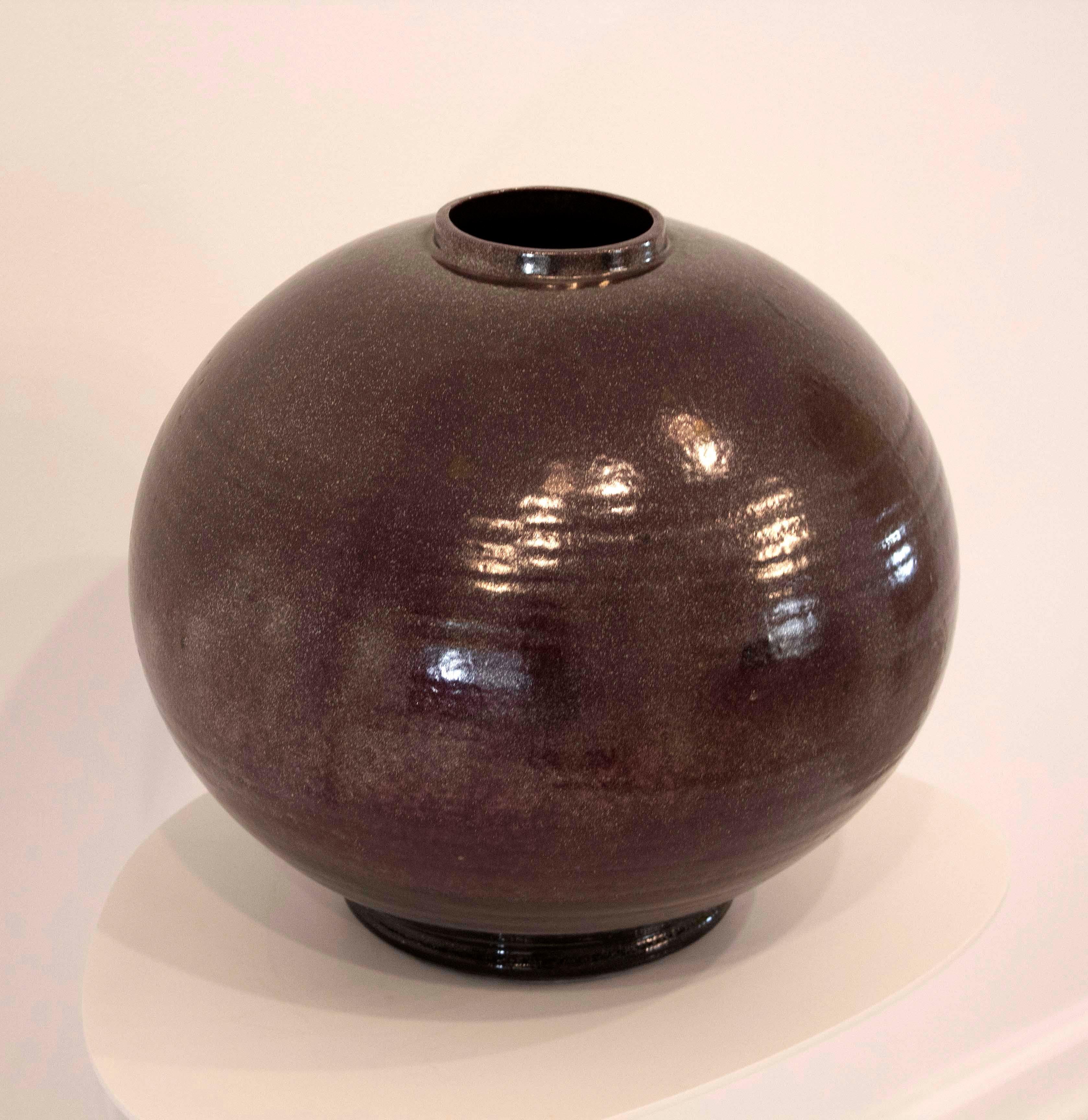 This lovely, hand-thrown cylindrical pottery vase is glazed in a purple hue and is signed 'Gary McCloy Los Angeles' on the bottom. In very good condition. Dimensions: 15