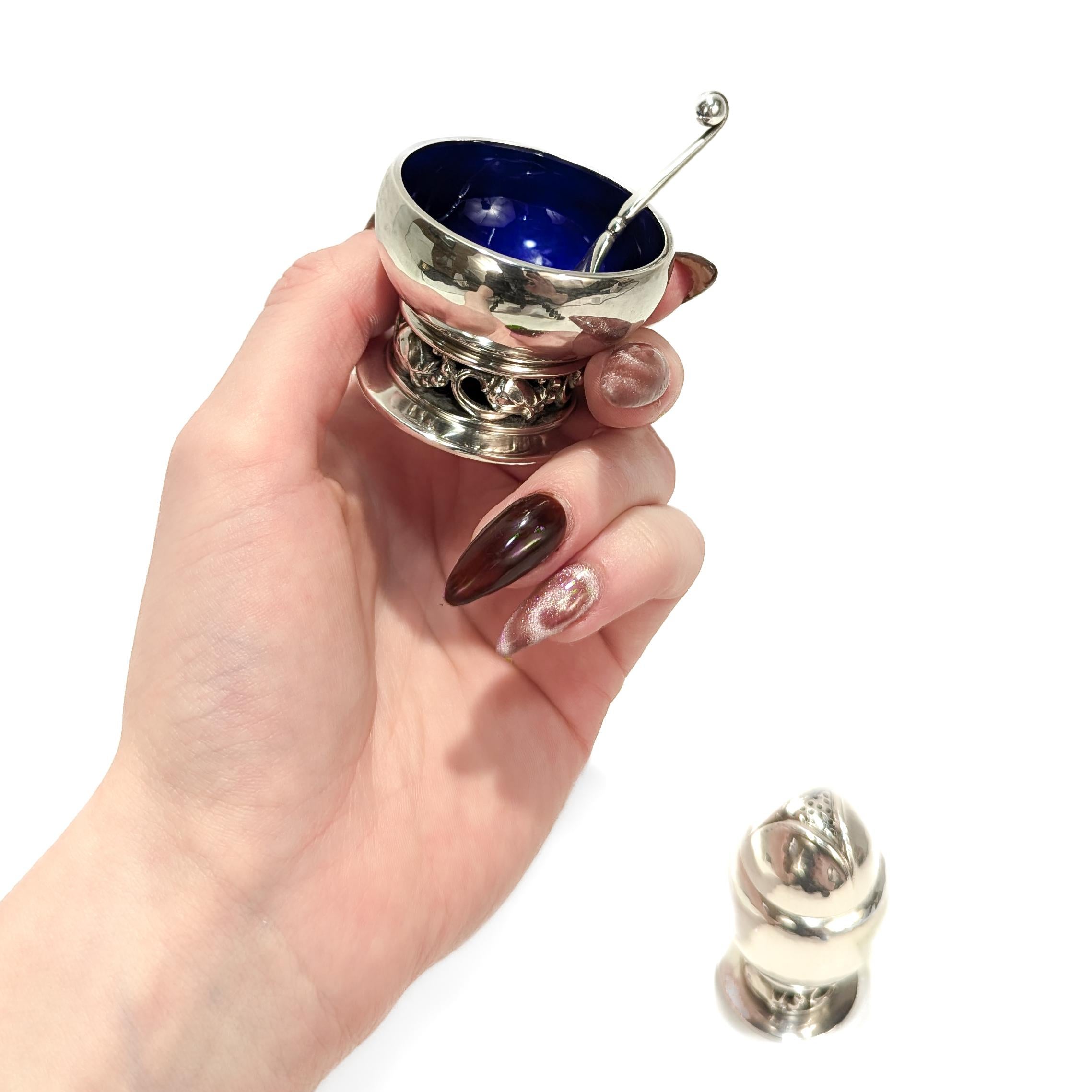 Paire de poivrières et de salières modernes danoises signées.

Par Georg Jensen.

En argent sterling.

Motif n° 2A, intitulé Blossom. 

Comprenant une poivrière, une salière ouverte avec un bol émaillé bleu cobalt, et une cuillère à sel