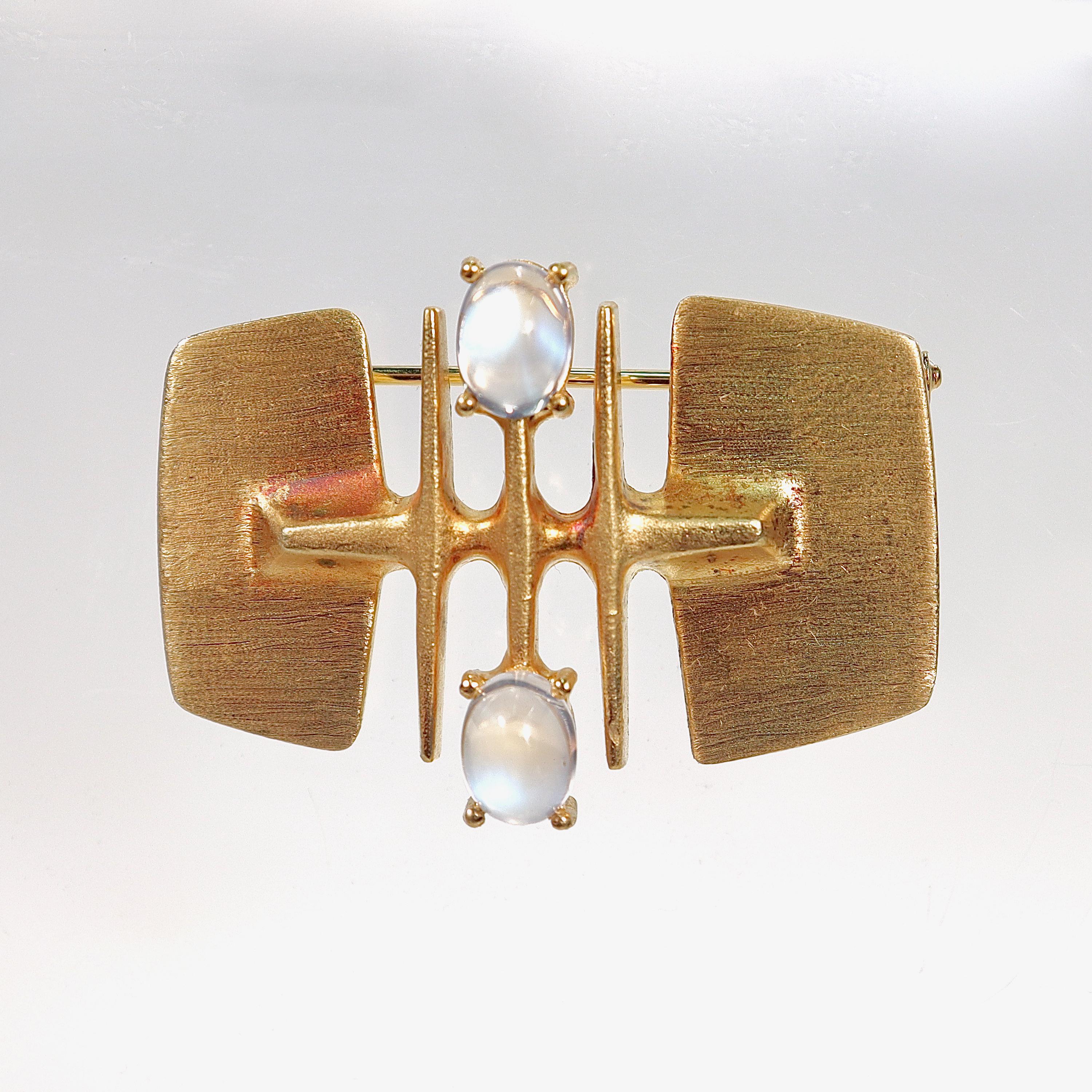 A fine German modernist brooch.

In 14 karat brush finished & high polished yellow gold 

With smooth oval moonstone cabochons prong set to both top and bottom. 

Marked 585 for 14k gold fineness and likely German. 

Simply a wonderful Modernist