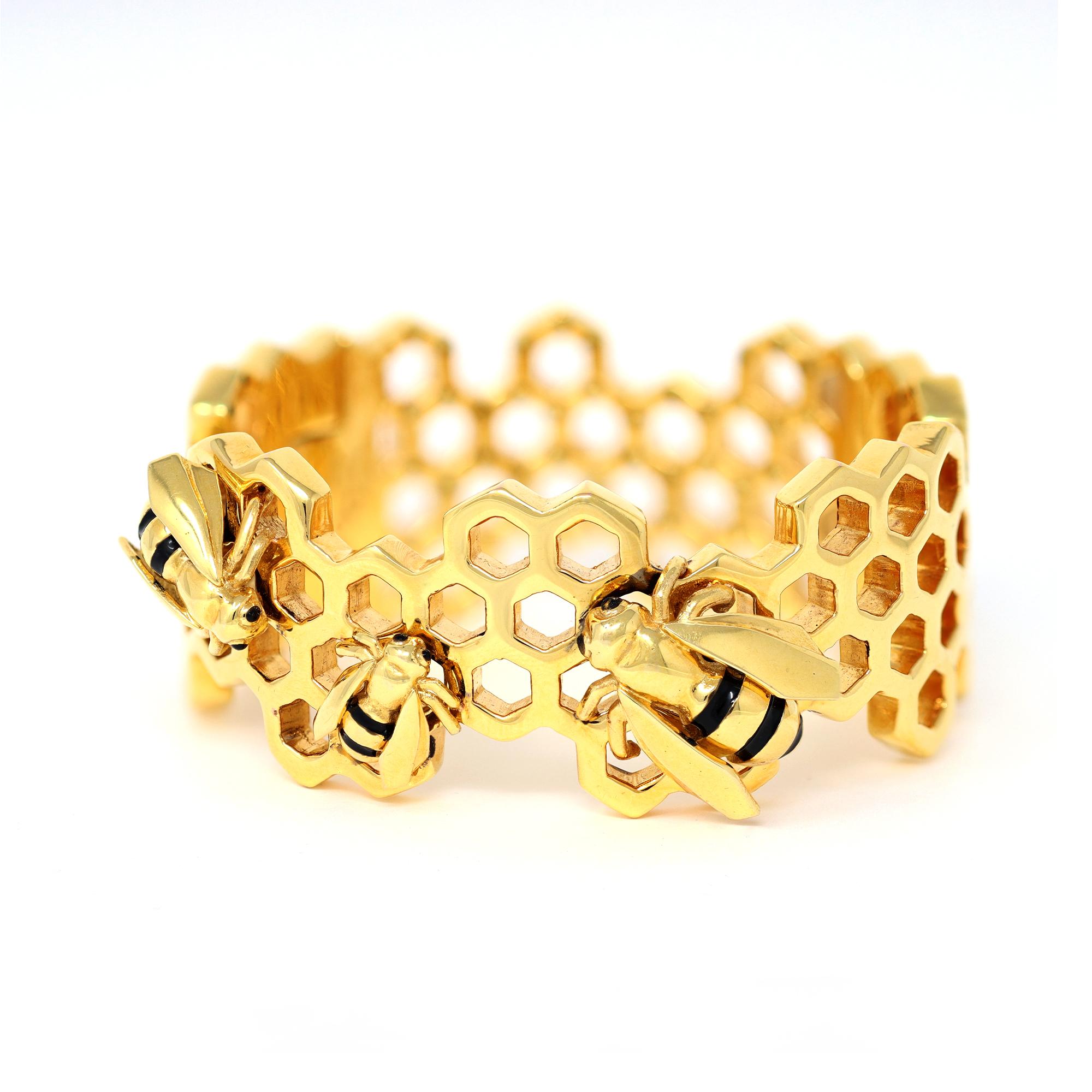 The hinged bangle is designed by Giordana Castellan, originated in Italy. The bracelet is made in 14 karat yellow gold and is accented by 3 black enemeled bees. The gross weight is 41.1 grams, length 6¾ inches, width 1⅛ inches, stamped Giordana