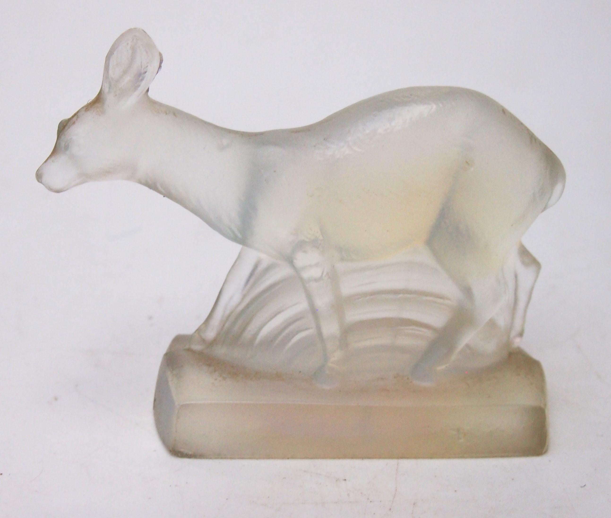 Très belle et exceptionnellement rare statuette ou presse-papier en forme de petit cerf opalescent, reposant sur une base rectangulaire et stylisée dans une forme Art Déco forte. L'animal est probablement un chevreuil. Cette pièce a été fabriquée