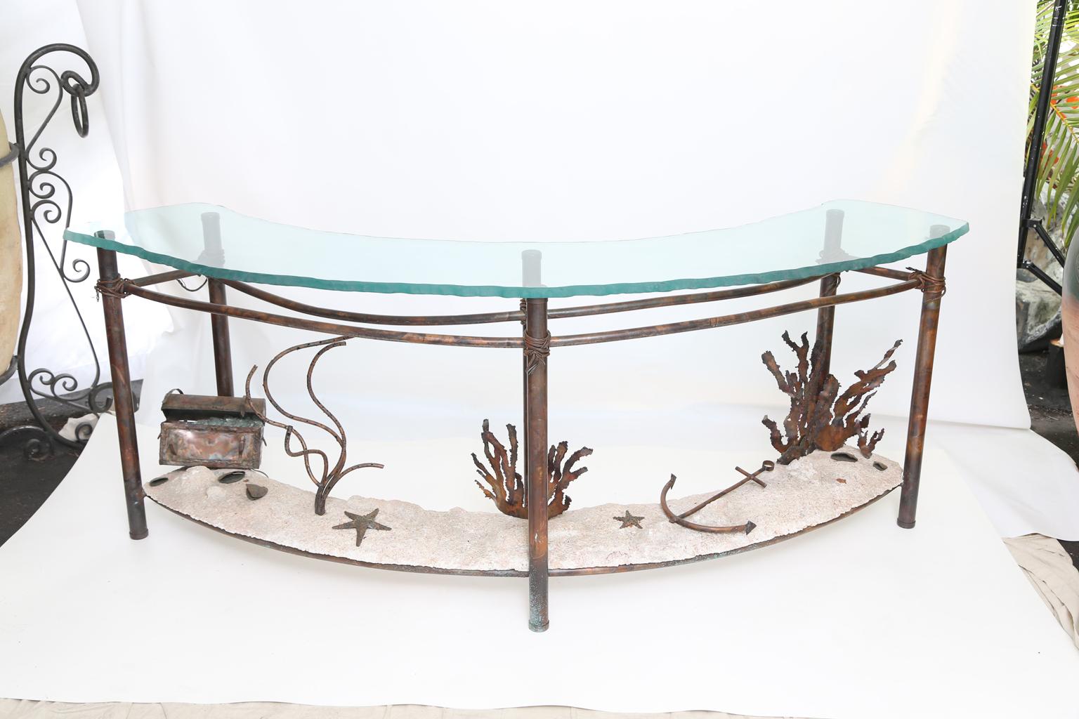 Demilune console table by artist Glen Mayo, its semi-circular top of 1 inch glass with rough-finish edge, on a base of copper, the six, wire-wrapped, legs are joined by a shelf stretcher of light-concrete 