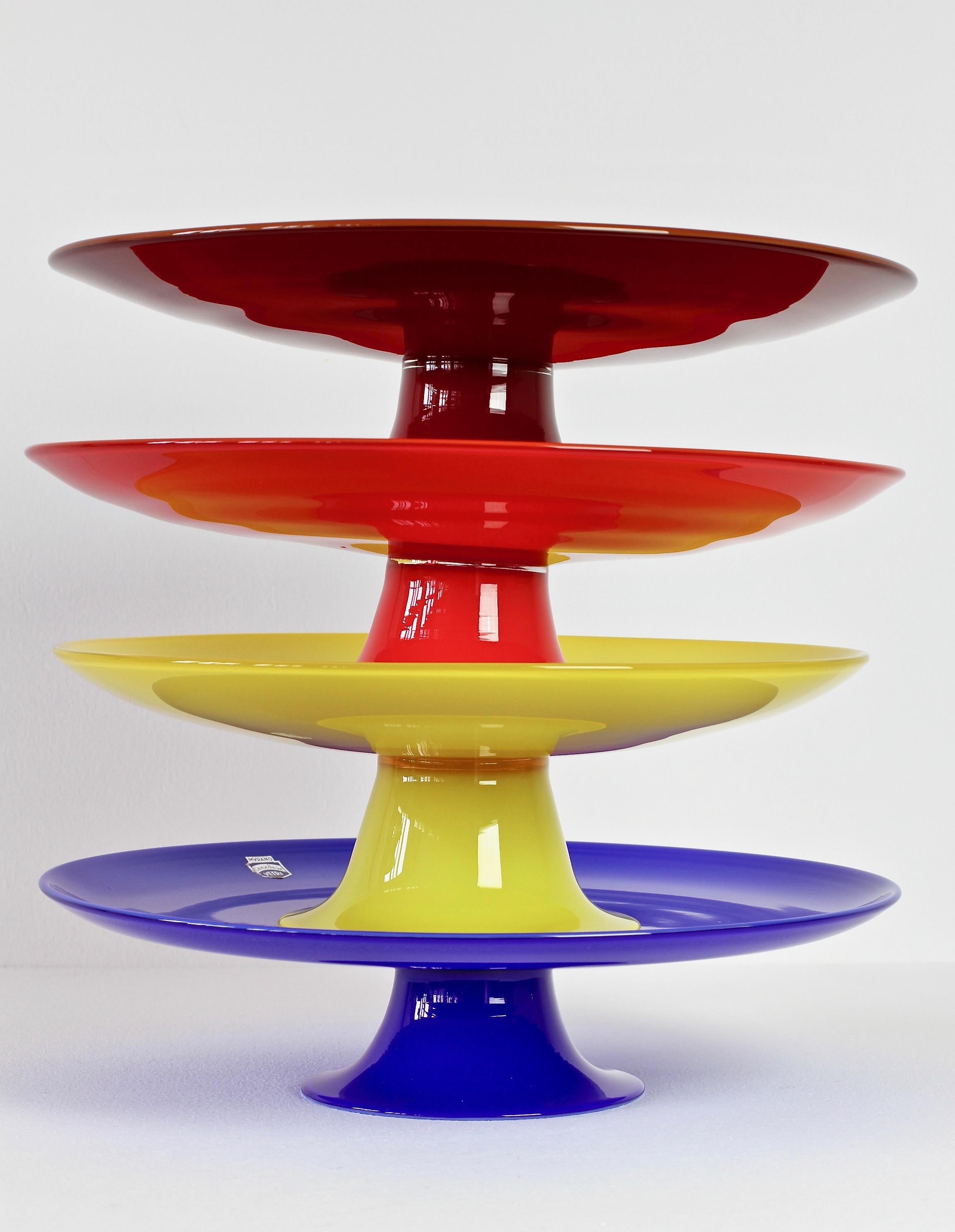 Signed set or ensemble of four midcentury Murano glass cake stands or serving dishes by Cenedese, circa 1970s. Wonderful colors of vibrant reds, blue and yellow. Simplistic yet elegant forms - almost futuristic. Very fun to dine with these vibrant