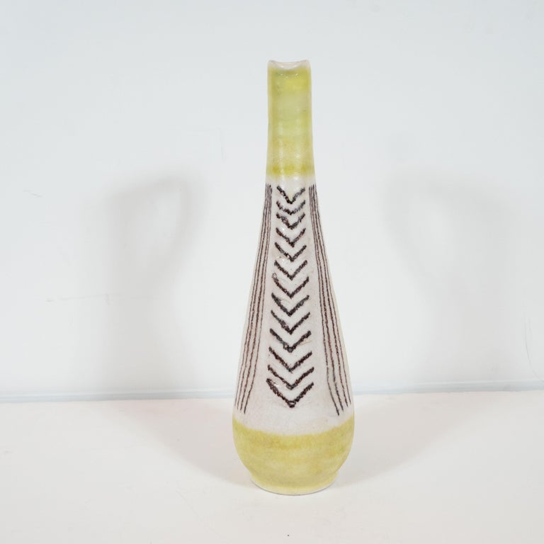 This elegant and sophisticated ceramic pitcher was designed by the celebrated 20th century artist Guido Gambone, crafted and hand painted in Italy, circa 1960. It features a conical body with a cylindrical neck and a flared base banded in a pale