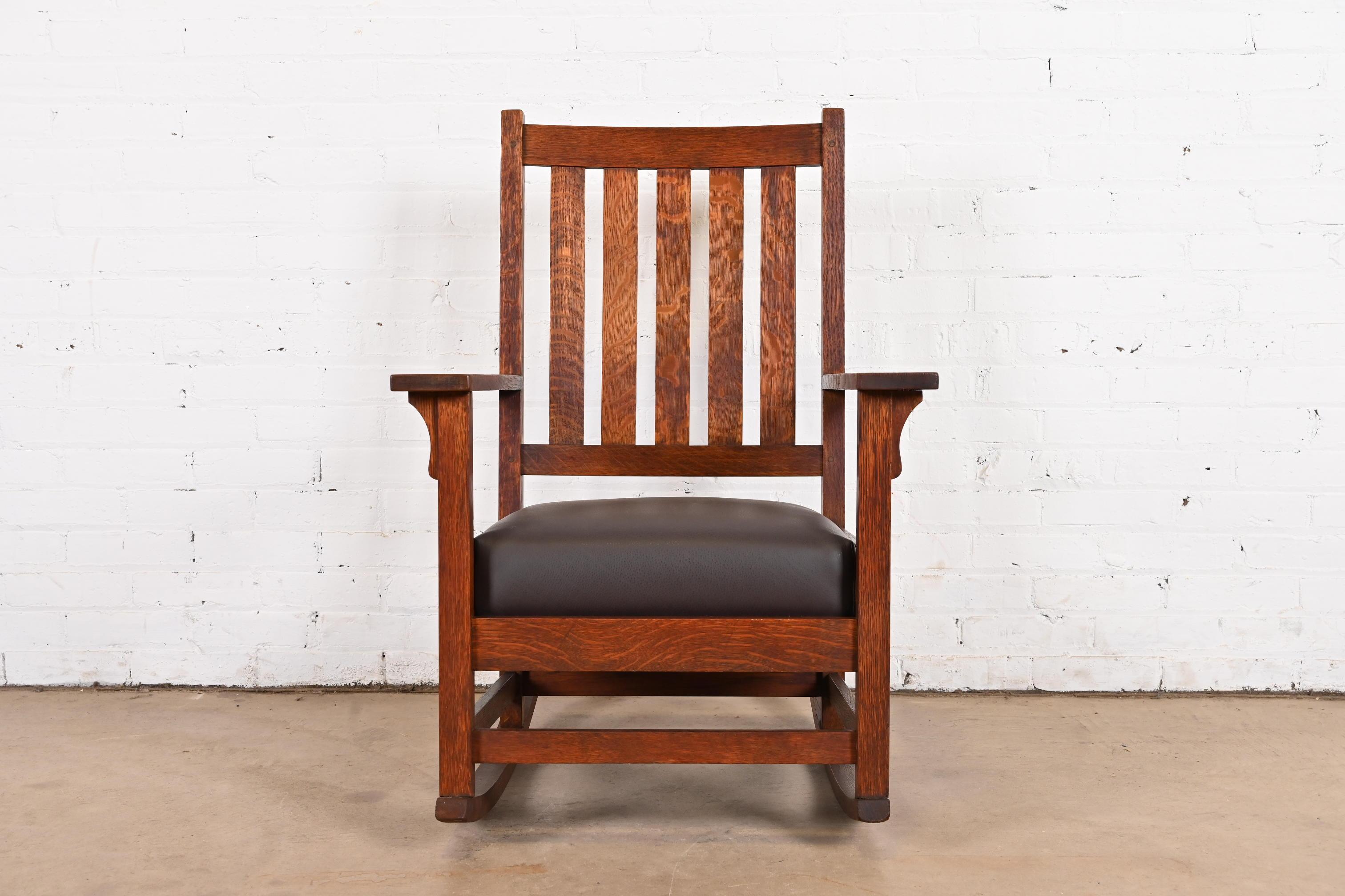 A gorgeous Mission oak Arts & Crafts rocker

By Gustav Stickley (signed with red decal)

USA, Circa 1900

Solid quarter sawn oak, with brown leather seat.

Measures: 25