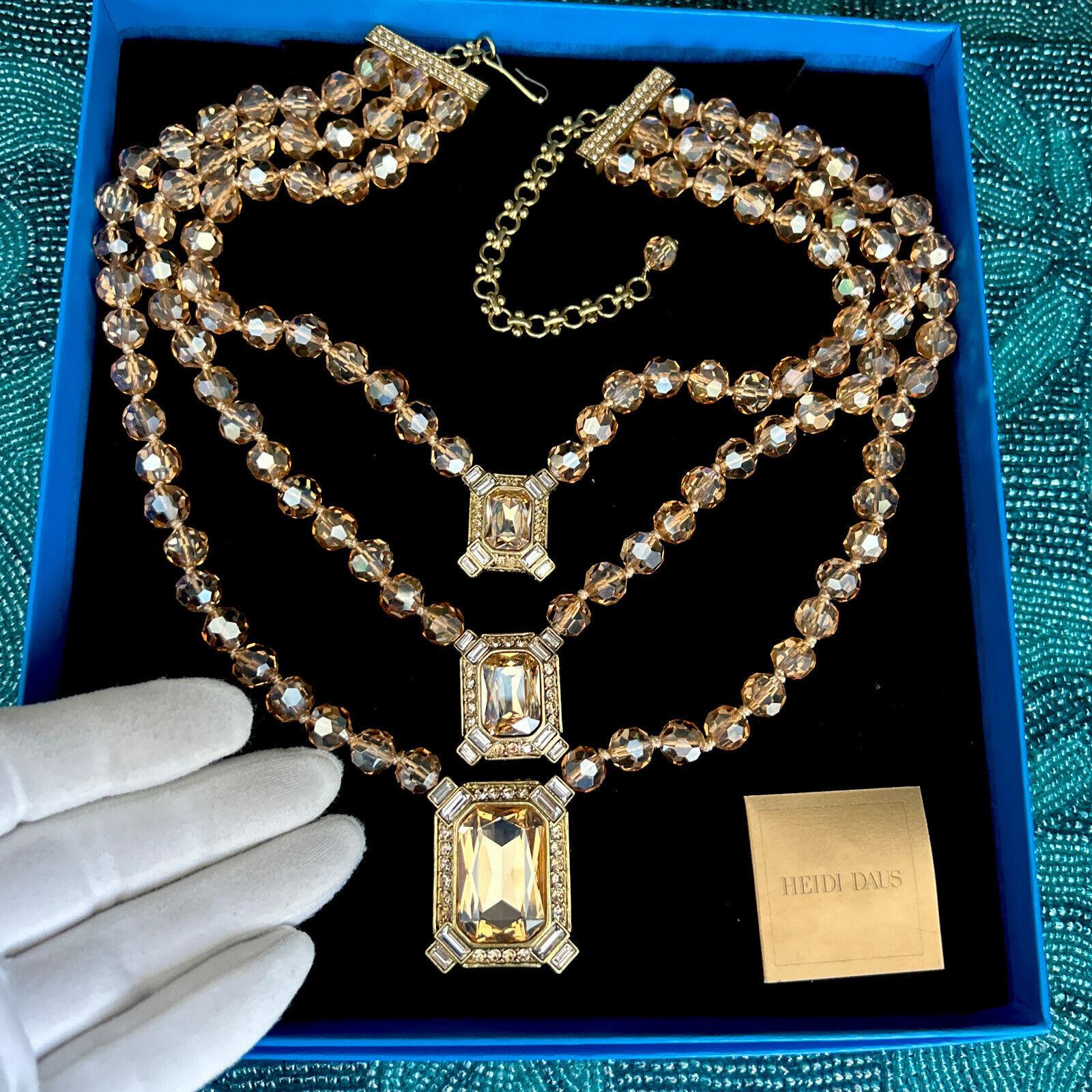 Simply Beautiful! Rare Heidi Daus Designer Triple Strand Golden Crystal Necklace. Each strand individually Hand Knotted Champagne colored faceted Beads features a Sparkling Crystal Pendant a rectangular Champagne Crystal, hand set  in Gold tone