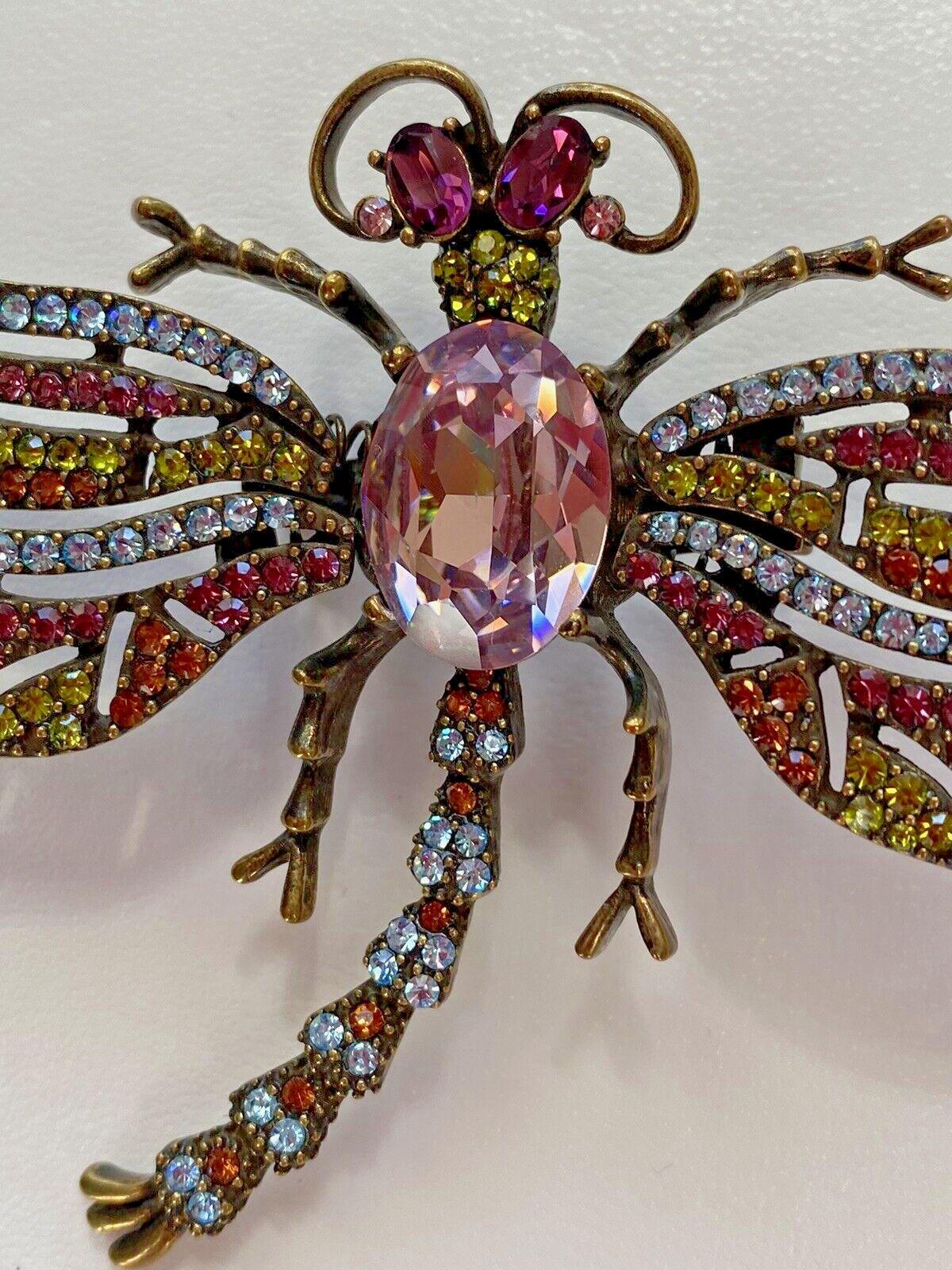 Simply Beautiful! Signed Heidi Daus Designer Tremblant Crystal Dragonfly Brooch Centering a Purple Amethyst Crystal. Surrounded by a myriad of pave Sparkling Crystals in blue, purple and green. Stunning Statement Brooch! Spring-loaded wings creating