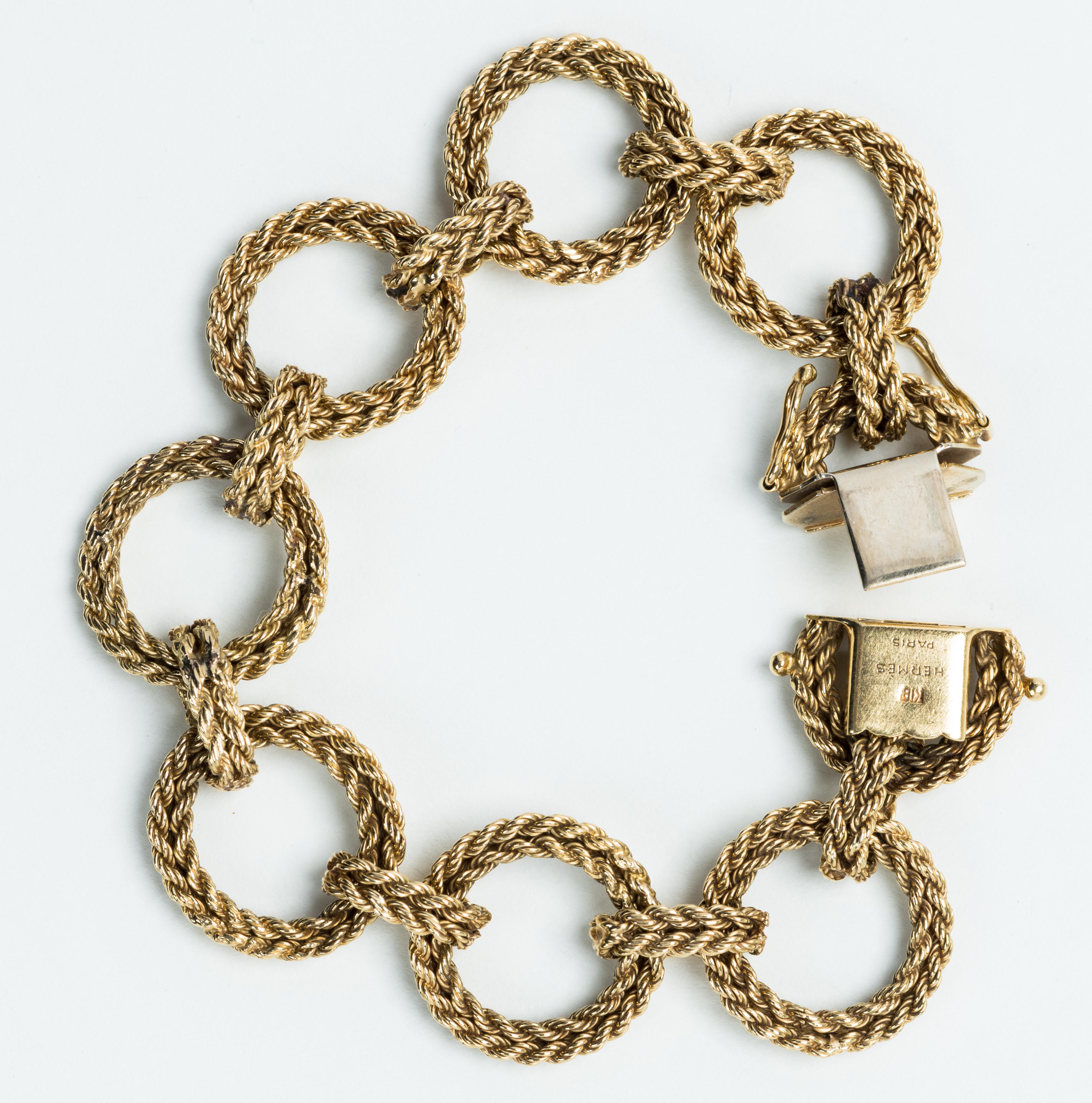 Signed Hermes 18 karat gold circular rope linked bracelet with two safety clasps, stamped Hermes Paris 18K, Circa 1960.

Size: L:  7”  W: 3/4”
Weight:  38.3 grams