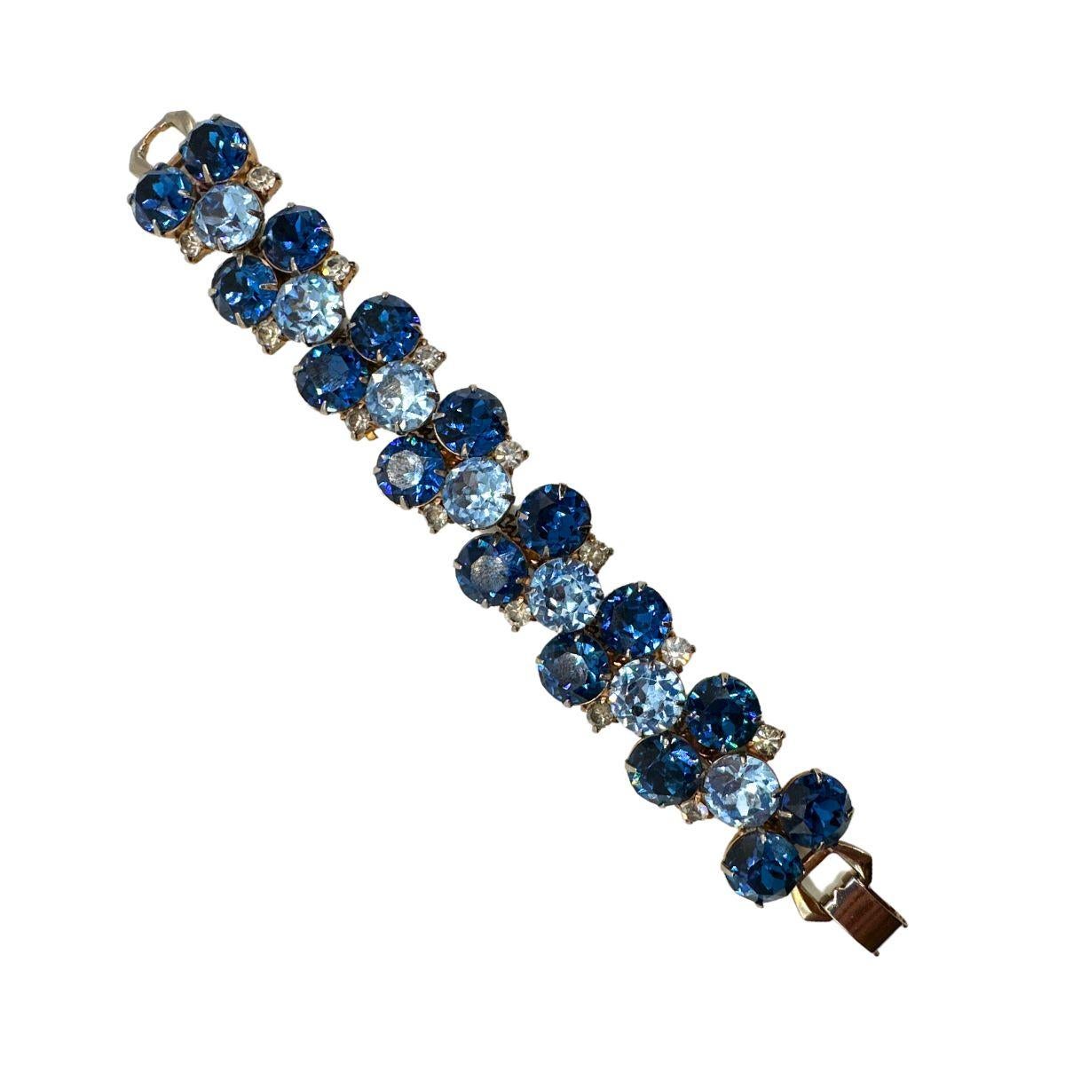Step into a world of vintage elegance with this exquisite Hobe Vintage Cobalt Blue and Light Blue Glass Bracelet and Earrings Set. Crafted with meticulous attention to detail, this stunning set showcases the timeless beauty and sophistication of