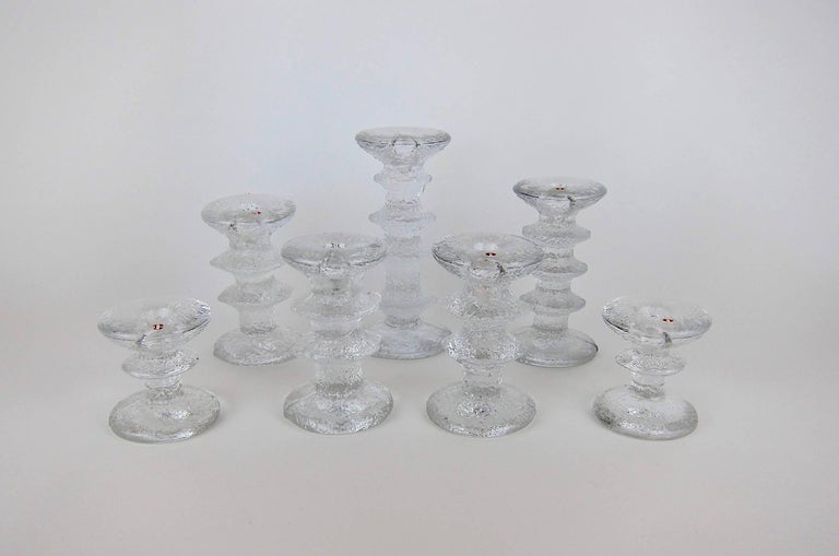A midcentury collection of seven Scandinavian clear glass candlesticks designed by Timo Sarpaneva for Iittala of Finland in 1966. The 