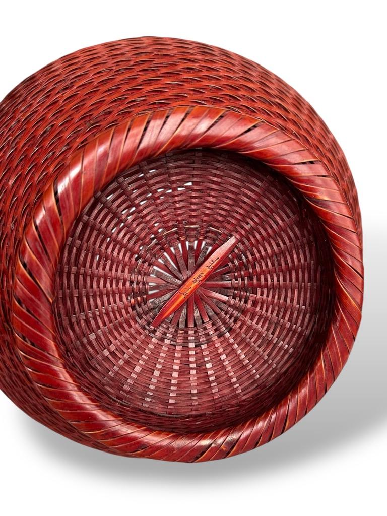 Panier à fleurs en bambou signé de Nishinaka Chikusei avec double poignée Looping
Japon, période Showa (milieu du 20e siècle)
Hauteur : 23,4 cm
Signé ; avec tomobako (boîte de rangement en bois) d'origine et revêtement intérieur en métal
