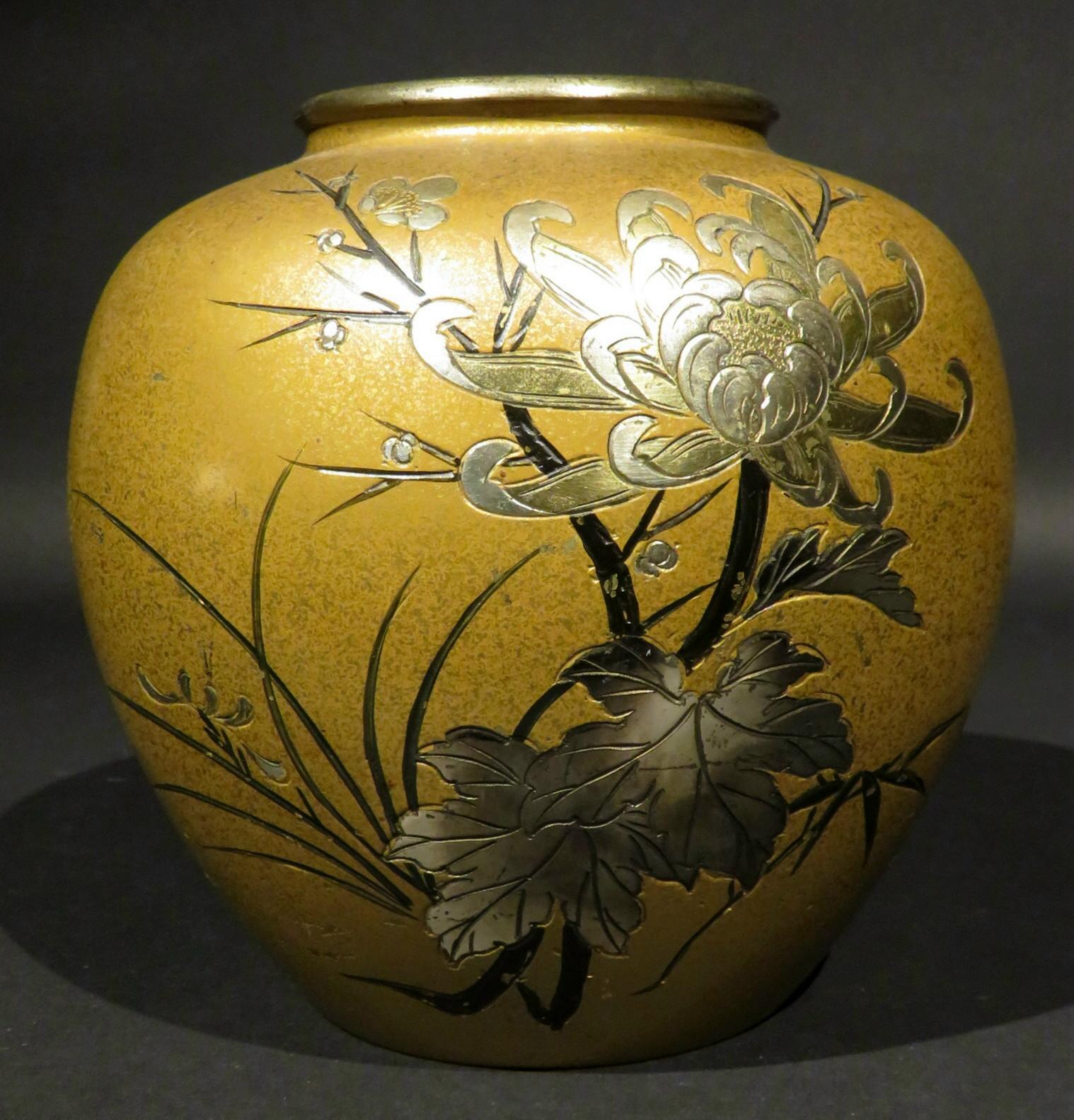 A very attractive signed Japanese mixed metal bronze vase of ovoid form, the gilt-patinated body decorated with silvered motifs of flowering chrysanthemum blossoms and leafy branches. Signed with incised character marks midway down the right side.
 