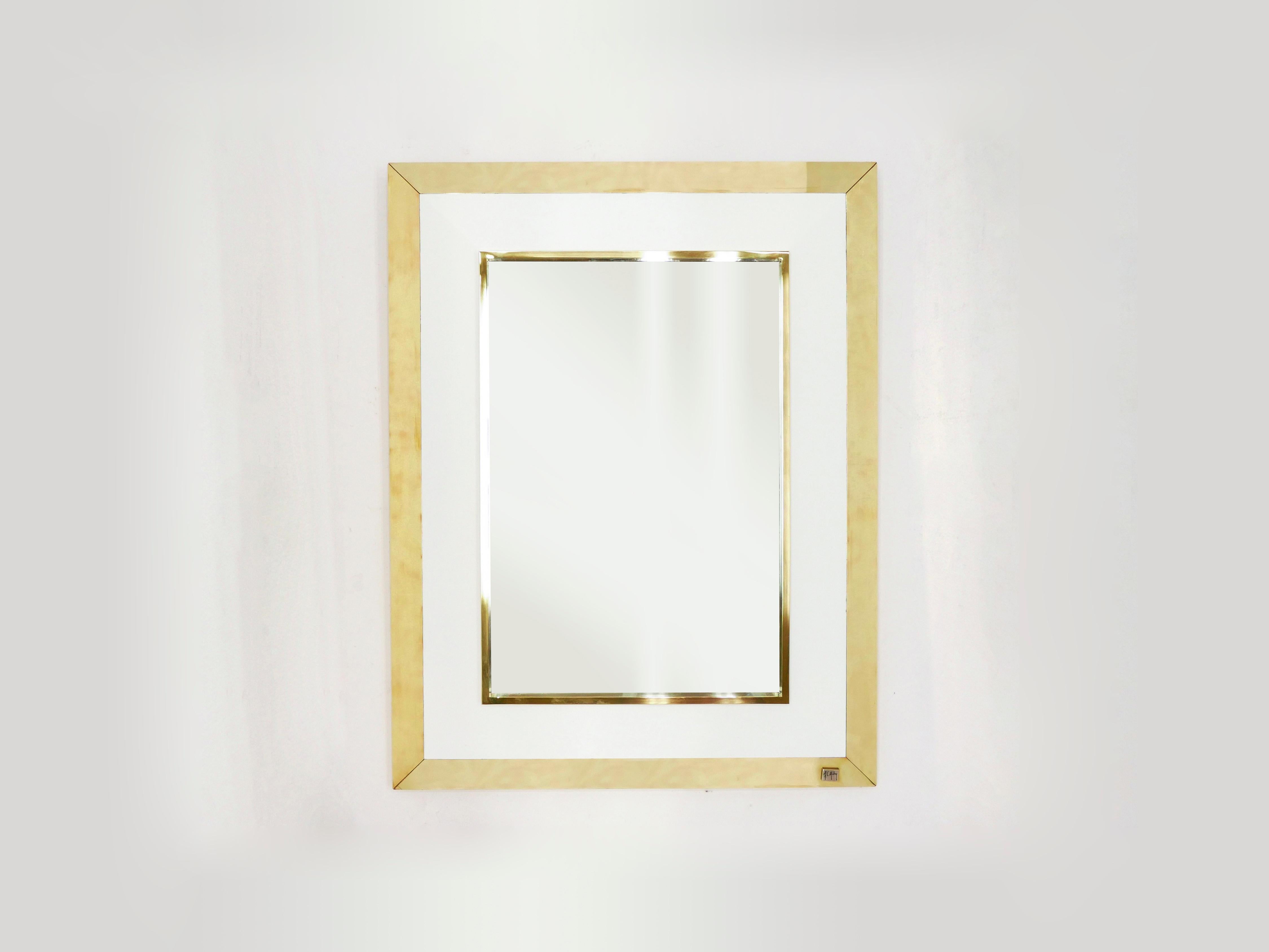 The white lacquer and brass make up the decorative frame of this beautiful wall mirror. A vintage style look contrasting with a contemporary finish. It was designed by Jean-Claude Mahey and edited by Romeo Paris in the 1970s. Fully cleaned, and in