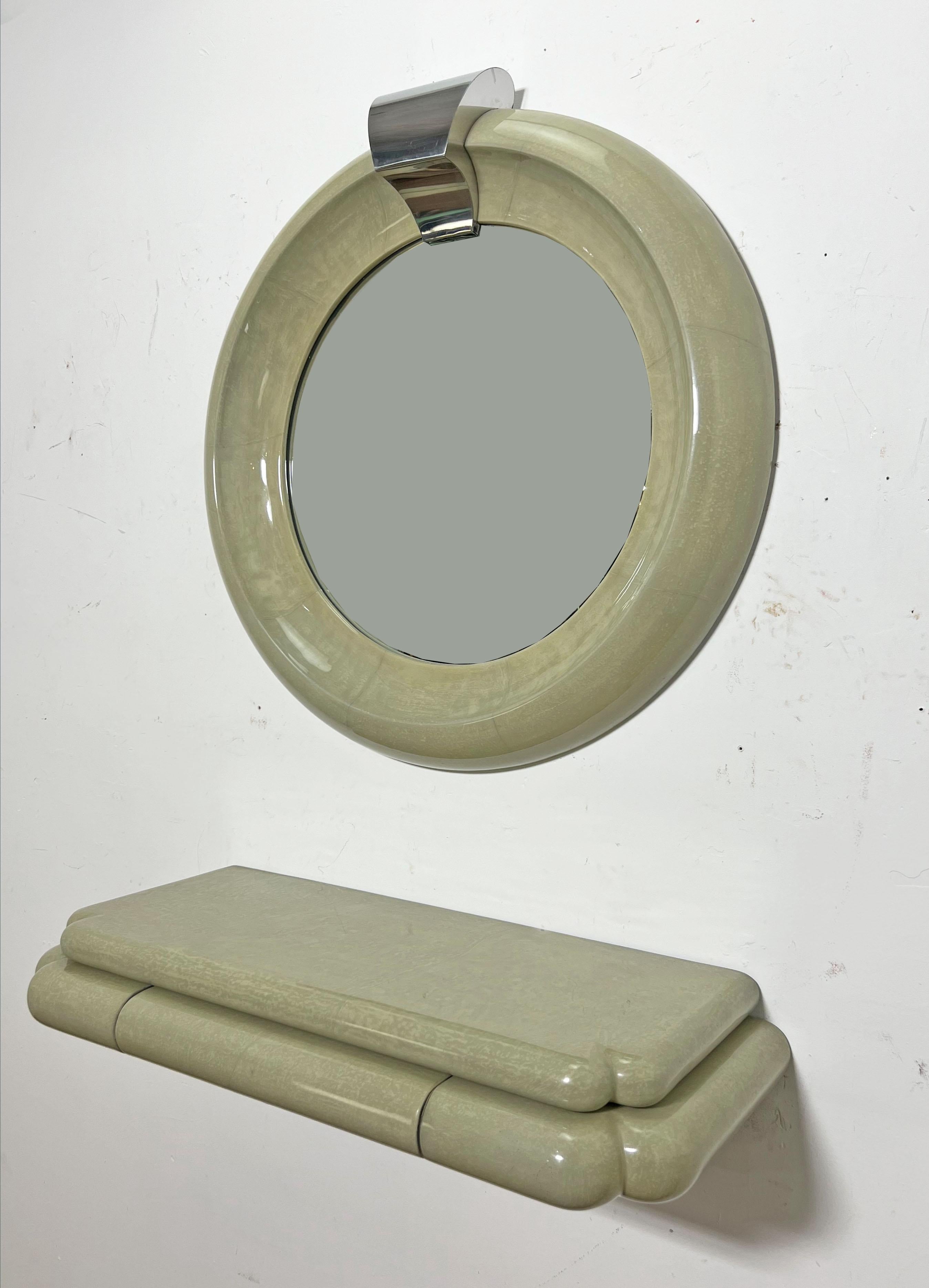 Signed Jimeco Ltda wall mirror and matching wall mounted console with single drawer, in celadon lacquered goatskin, made in Columbia and dated 1987.

Mirror measures: 37