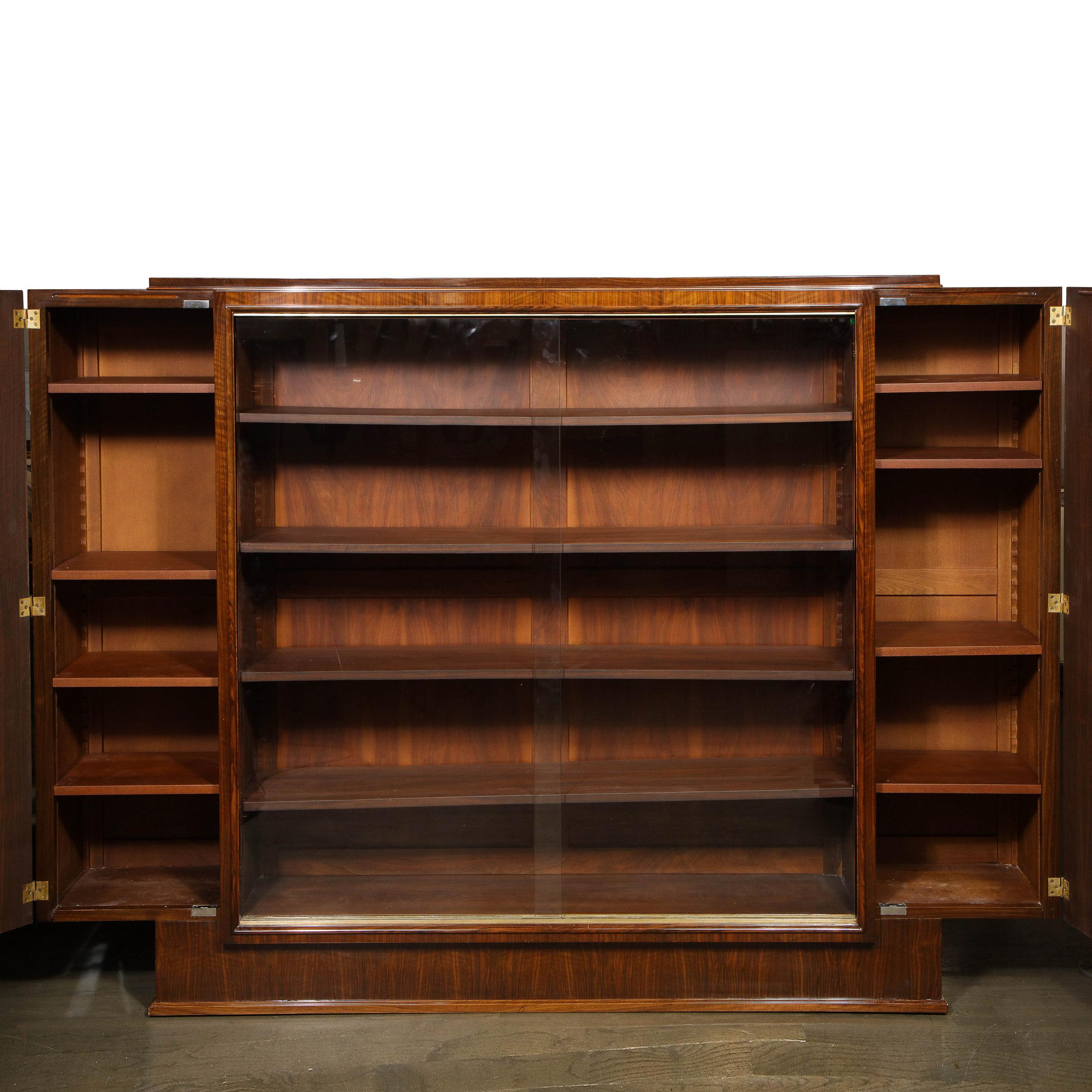 This stunning and important cabinet / Bibliothèque as realized by the celebrated French designer Jules Leleu in France, circa 1930. The piece executed in bookmatched rosewood offers a cubist skyscraper style rectilinear form with base that protrudes