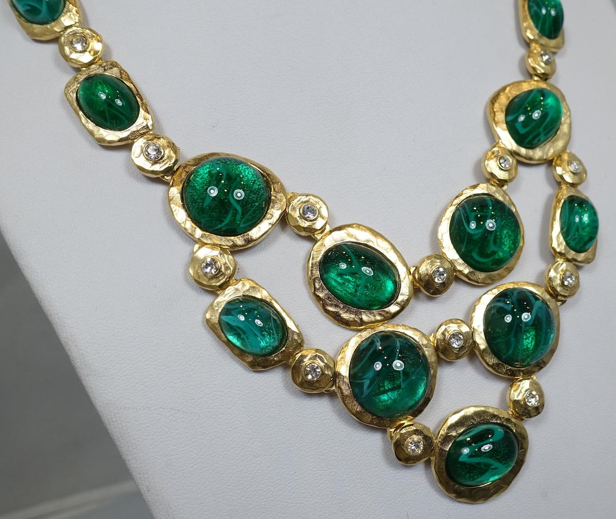 This signed Kenneth J. Lane necklace features green marbleized cabochon cut stones with clear rhinestone accents in a gold-tone metal setting. This necklace has an inside measurement of 20”; a single large disc is 1” wide. This necklace has a hook