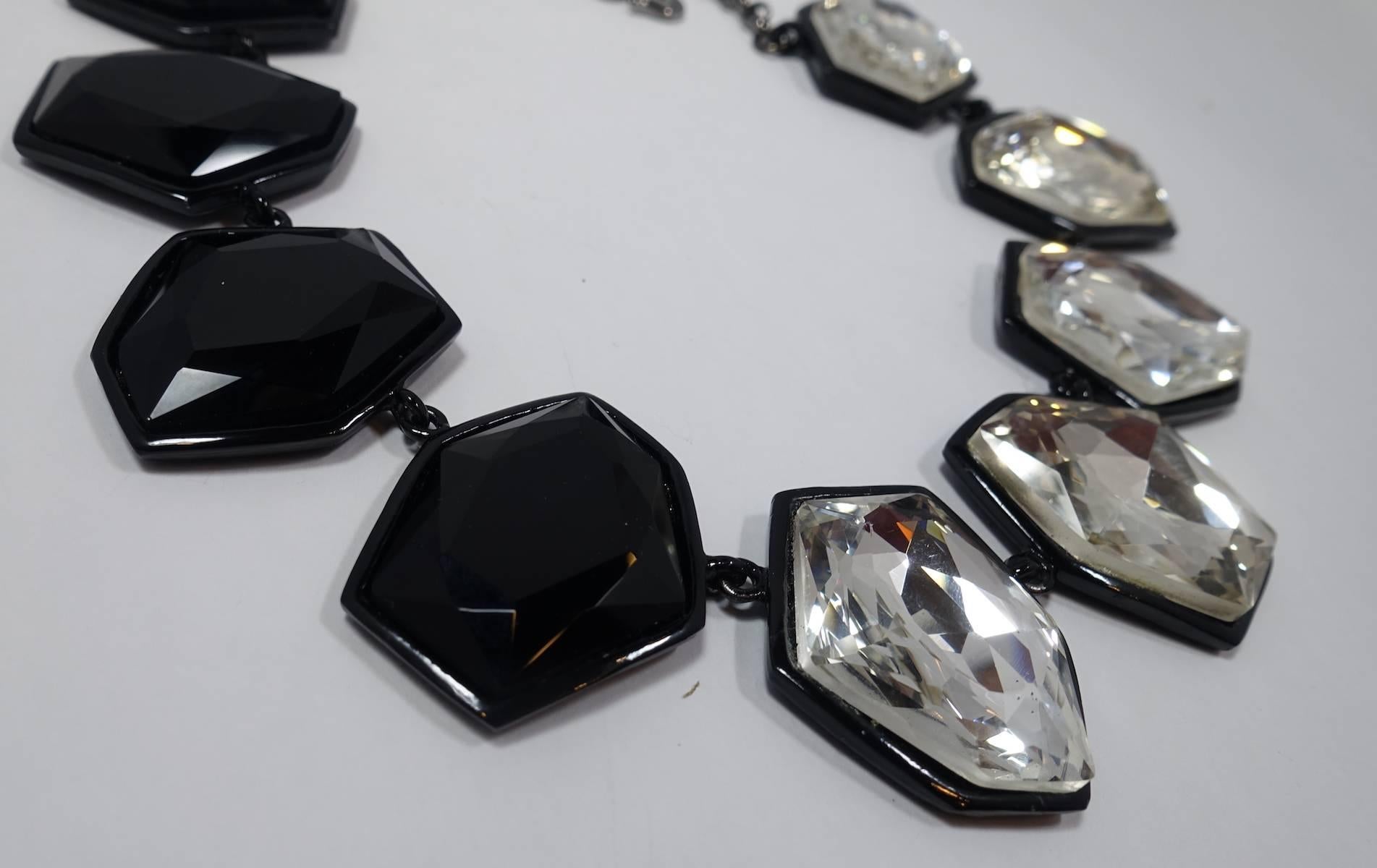 This Kenneth Lane necklace features faceted clear and black “headlight” crystals in a Japanned setting. This necklace measures 21” long with a hook closure x 1-7/8” and is signed “Kenneth Lane”.  This necklace is in excellent condition.